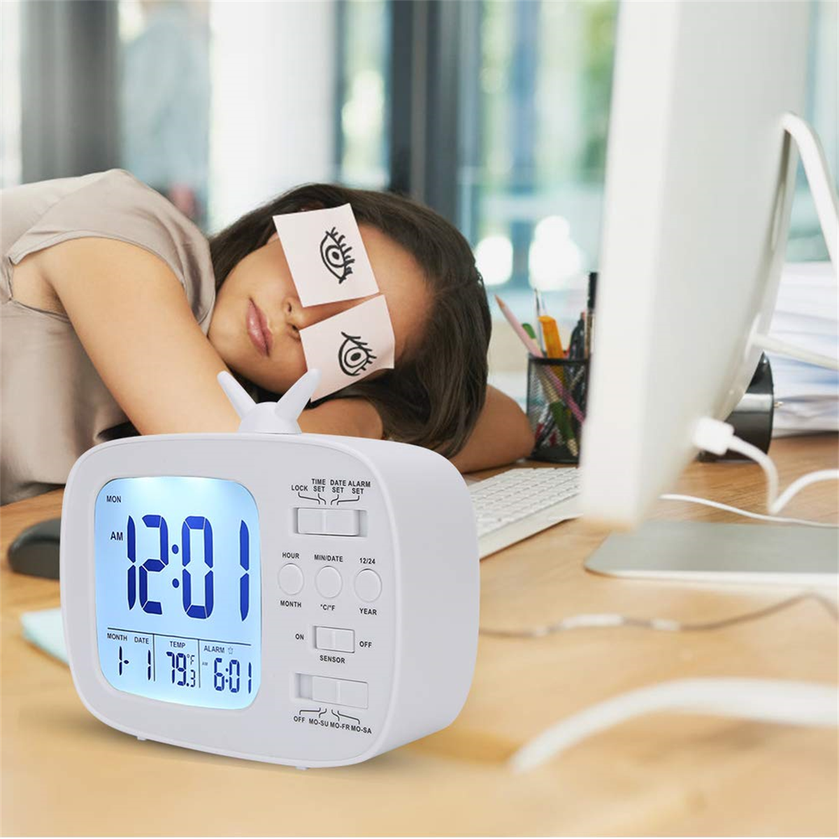 Eine Frau schläft mit Haftnotizen auf den Augen in der Nähe einer weißen Uhr. Rechts ist ein Computer.