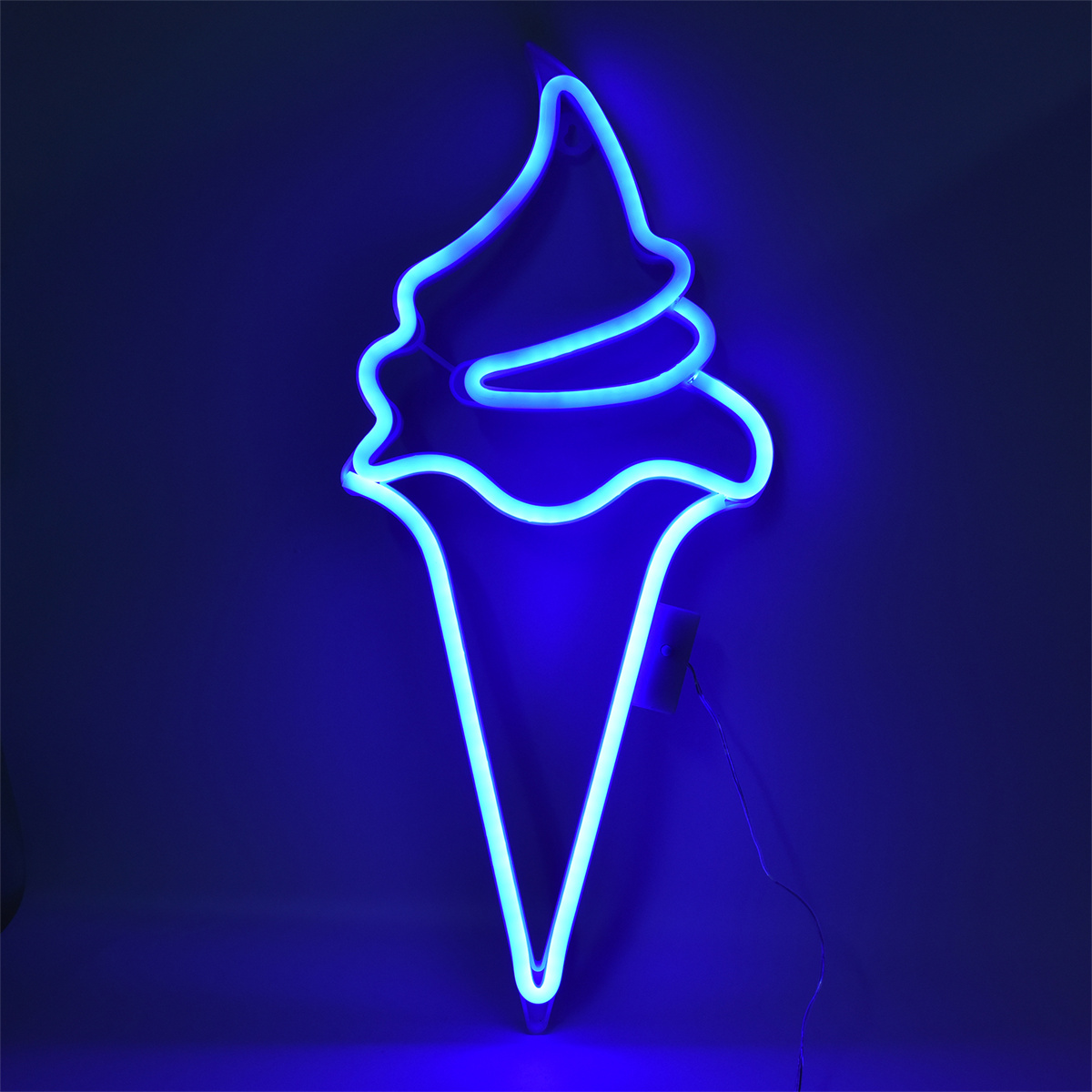 Ein blaues Neon-Eistüten-Schild an einer dunkelblauen Wand, das einen leuchtenden Effekt erzeugt.