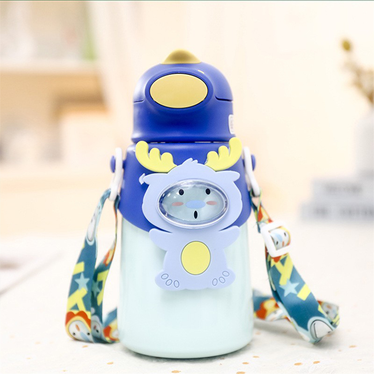 Blaue und weiße Cartoon-Wasserflasche mit Riemen. Die Flasche hat eine Cartoonfigur. Weißer Hintergrund.