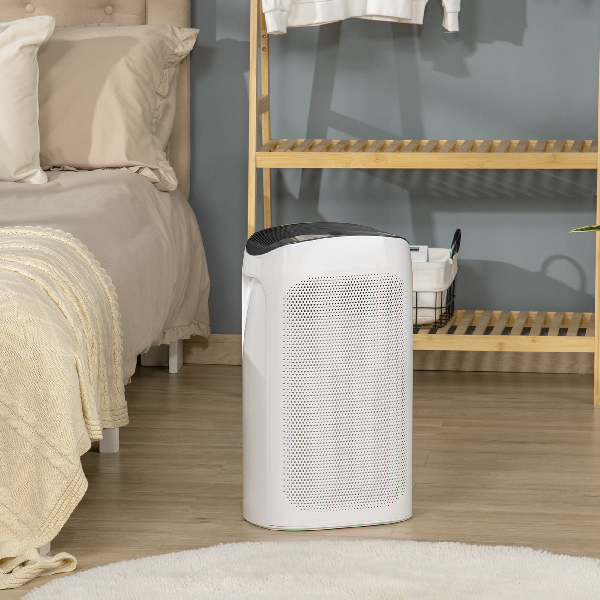 Purificatore d'aria bianco contro uno sfondo di camera da letto. Letto e scaffale in legno visibili nella stanza.