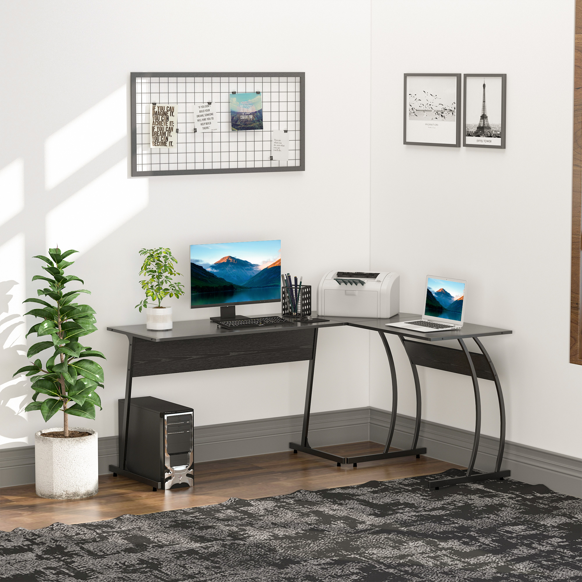 Un escritorio negro en forma de L en una esquina, con accesorios de computadora, plantas e imágenes en la pared.