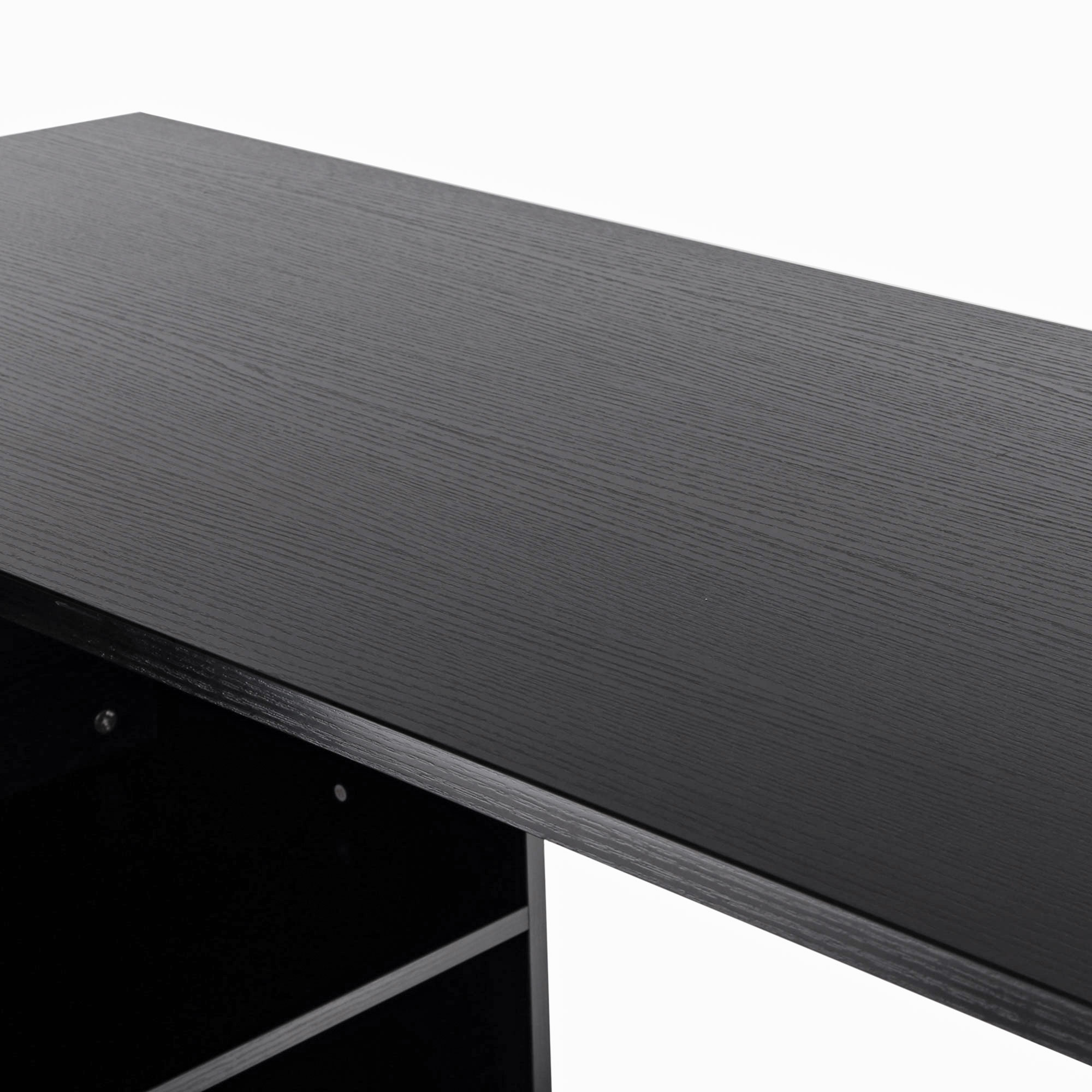Primo piano di un piano scrivania nero. La venatura del legno è visibile. Il bordo della scrivania è a fuoco.