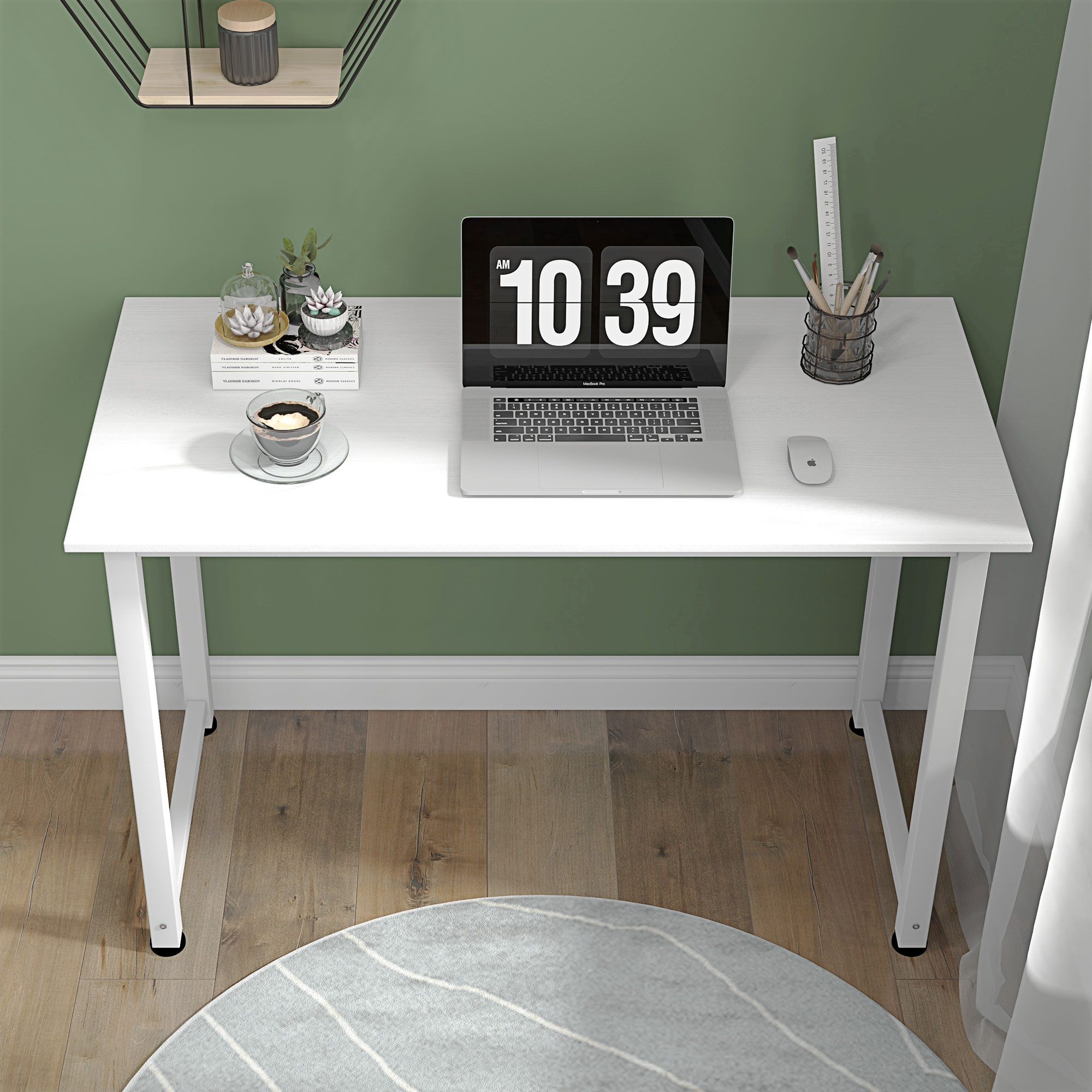 Una scrivania bianca con laptop, caffè e forniture. Ha un muro verde e un tappeto grigio.