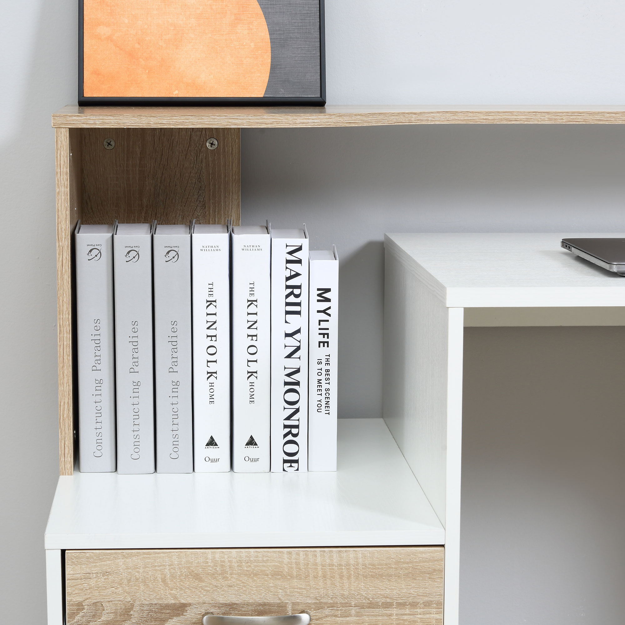 Primo piano di libri su una mensola attaccata a una scrivania bianca.