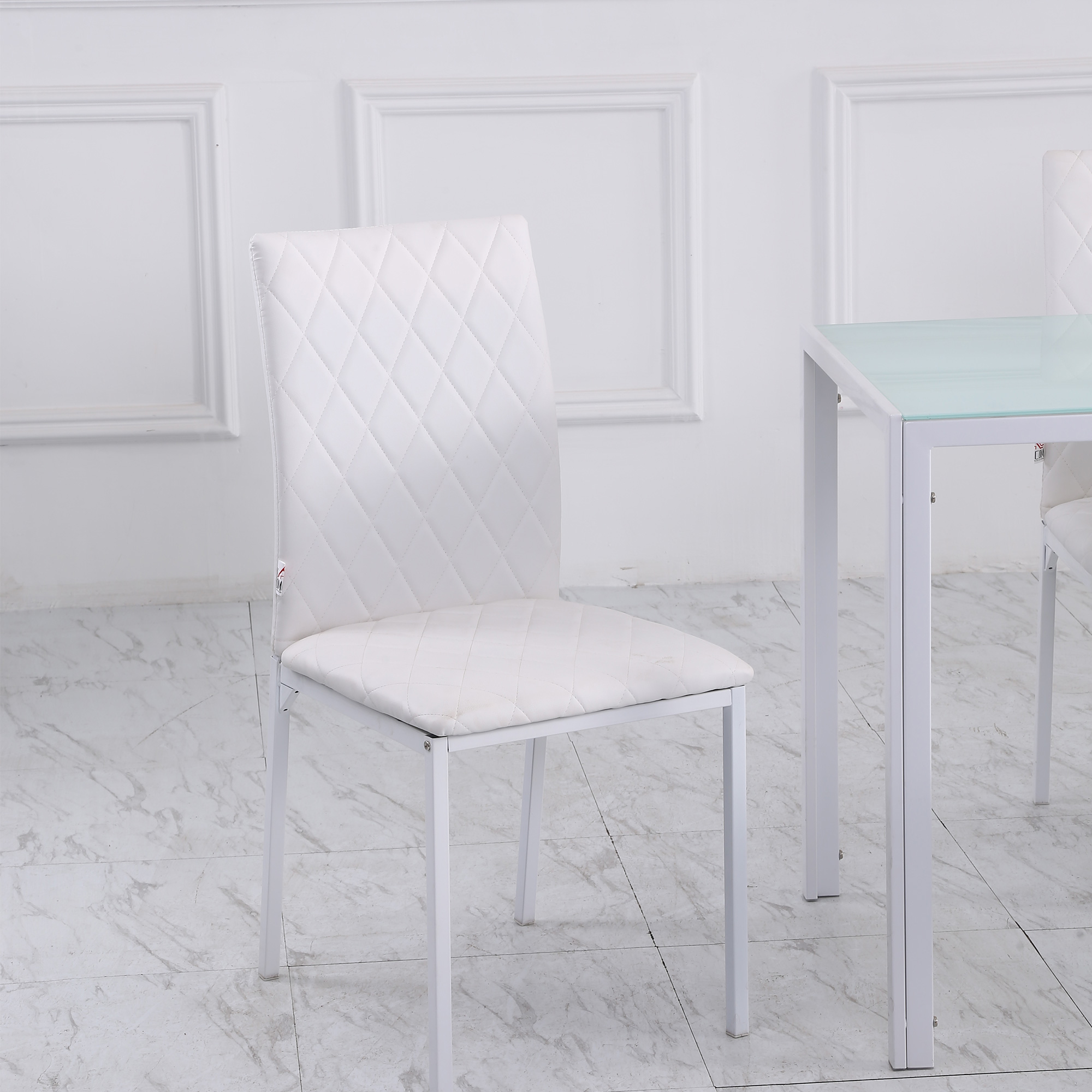 Sedia bianca in una stanza con sfondo bianco e tavolo bianco. Design semplice e pulito.