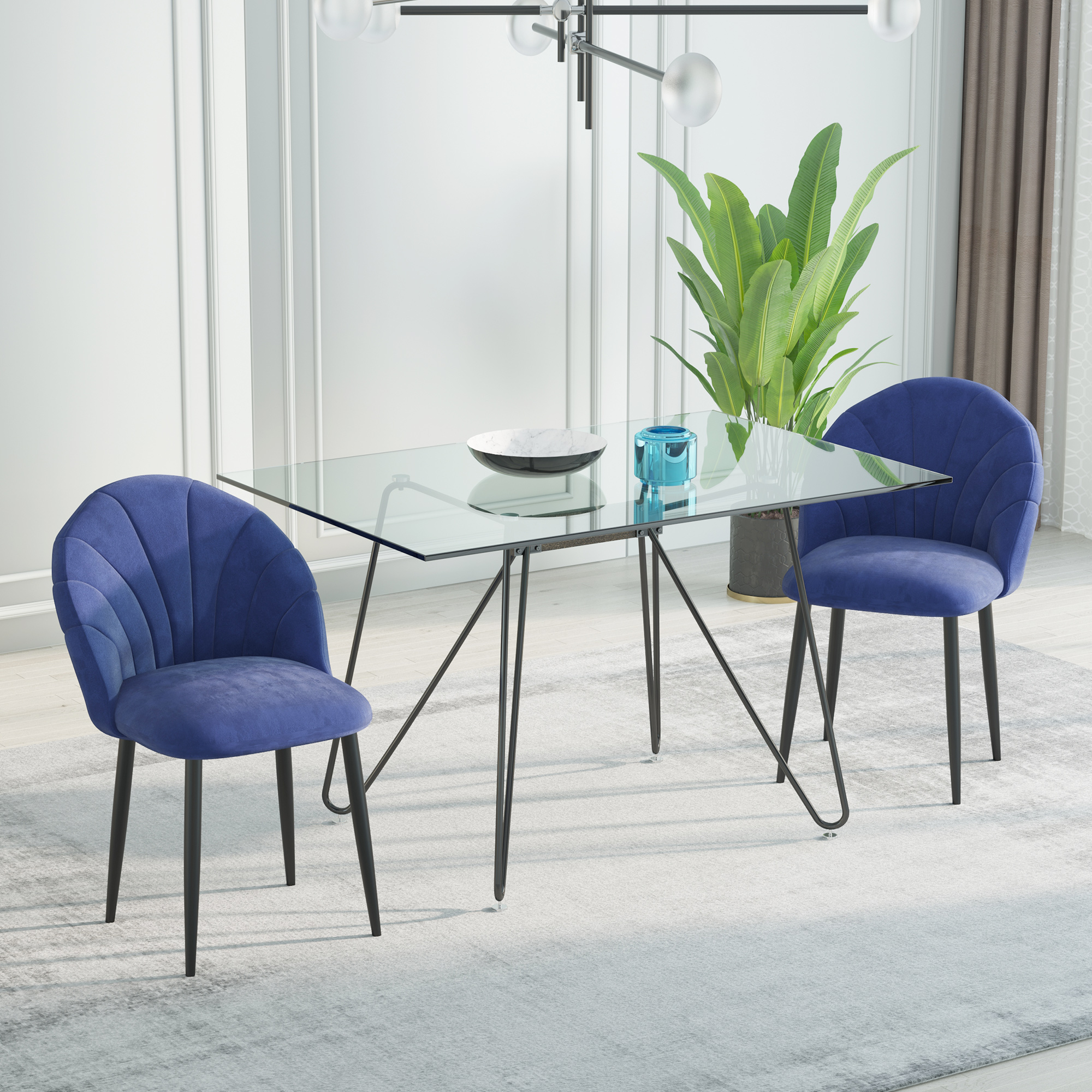 Un tavolo con piano in vetro e due sedie blu. Una pianta, una ciotola e decorazioni completano la scena.