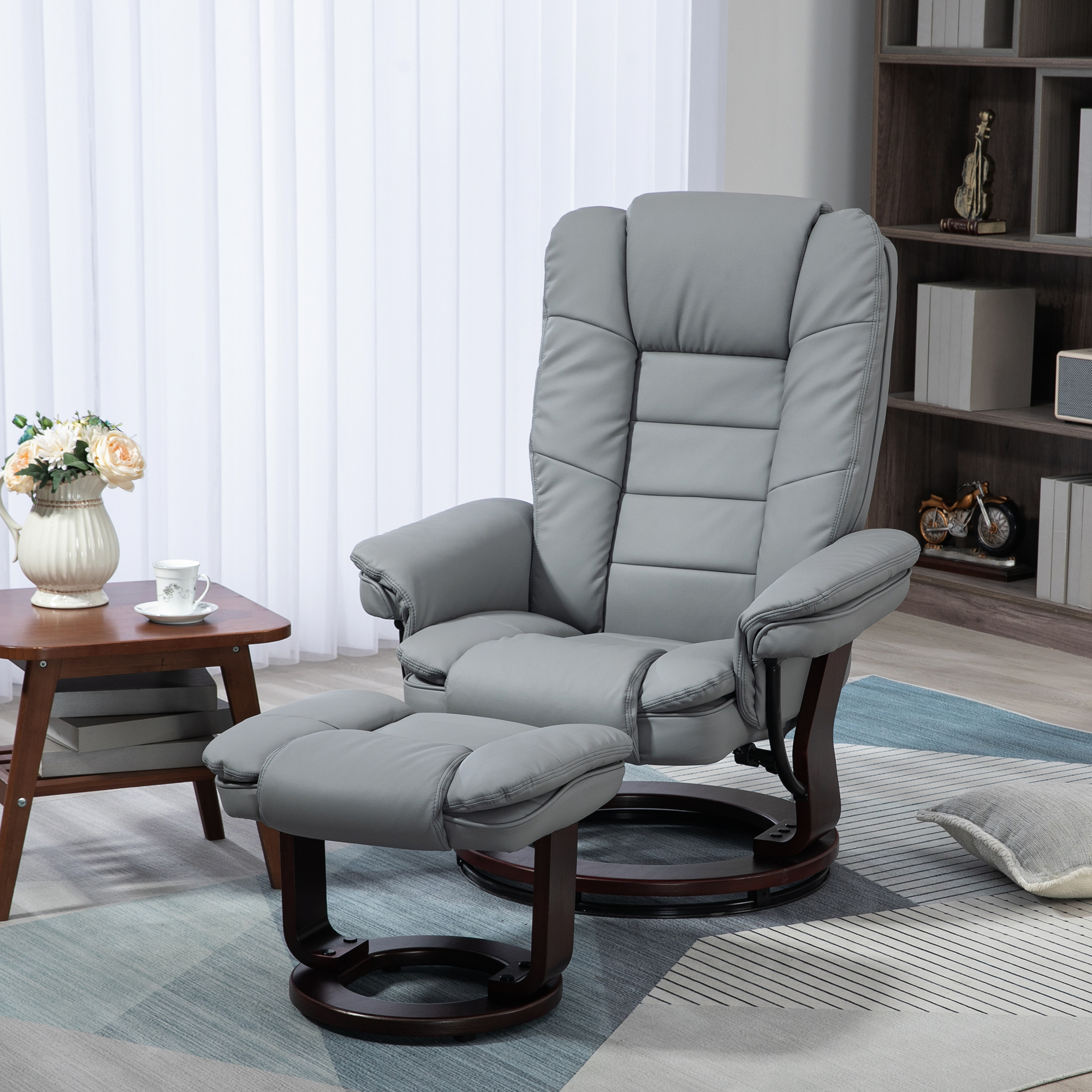 Poltrona reclinabile in pelle beige con pouf. Pavimento in legno, libreria e tavolino con vaso e tazza.