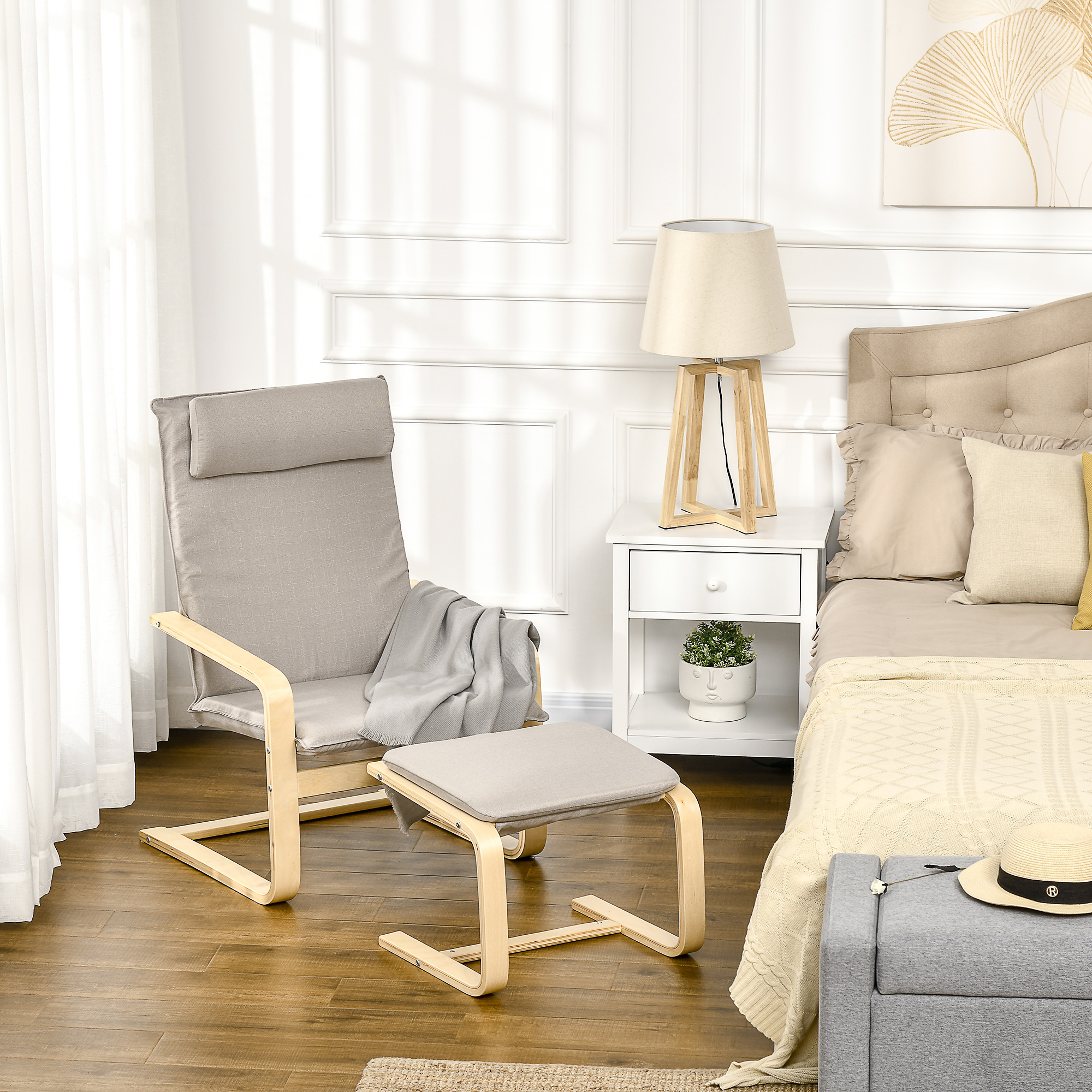 Una sedia grigia con un pouf accanto a un letto.