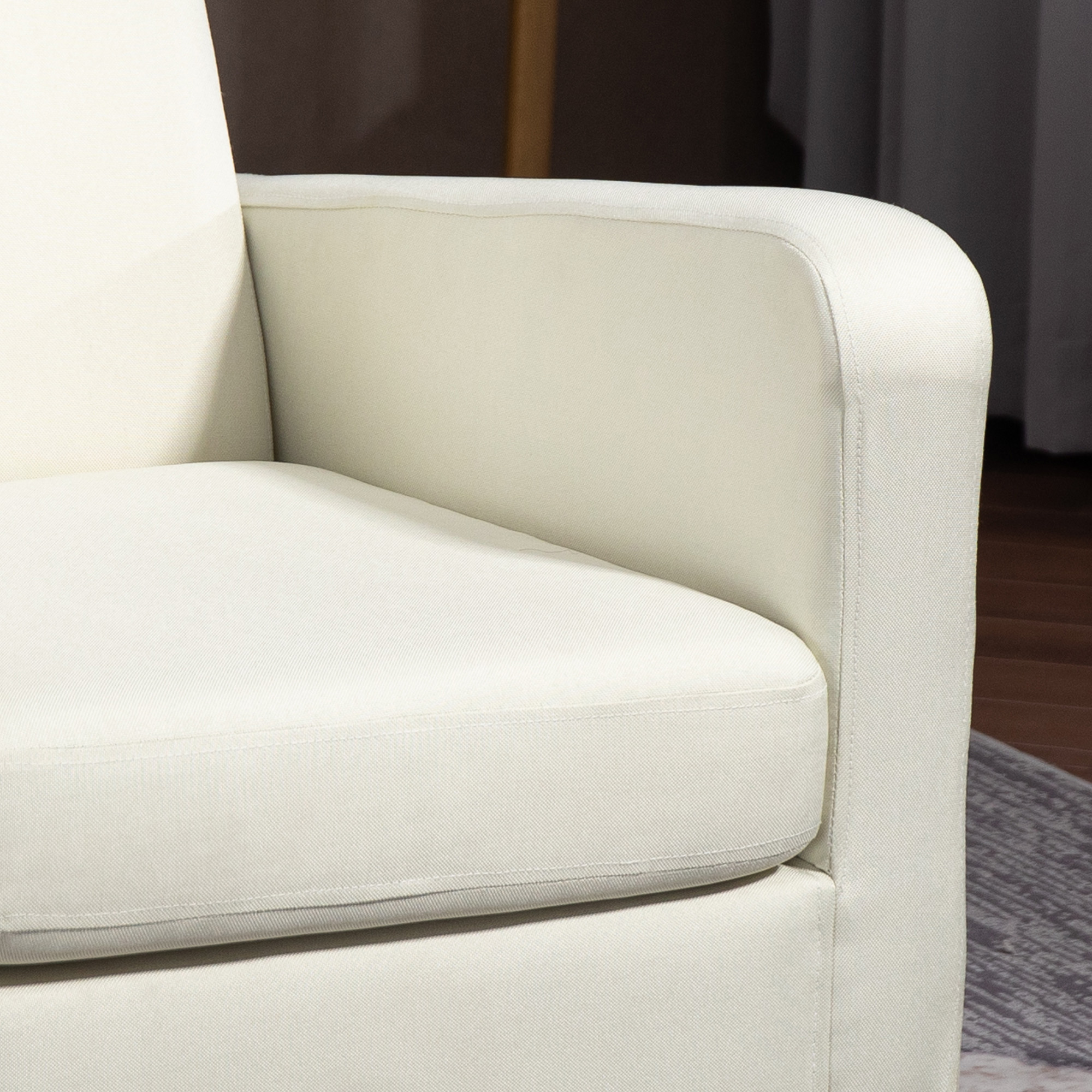 Primo piano di un bracciolo color crema di una sedia. Anche il sedile è color crema.