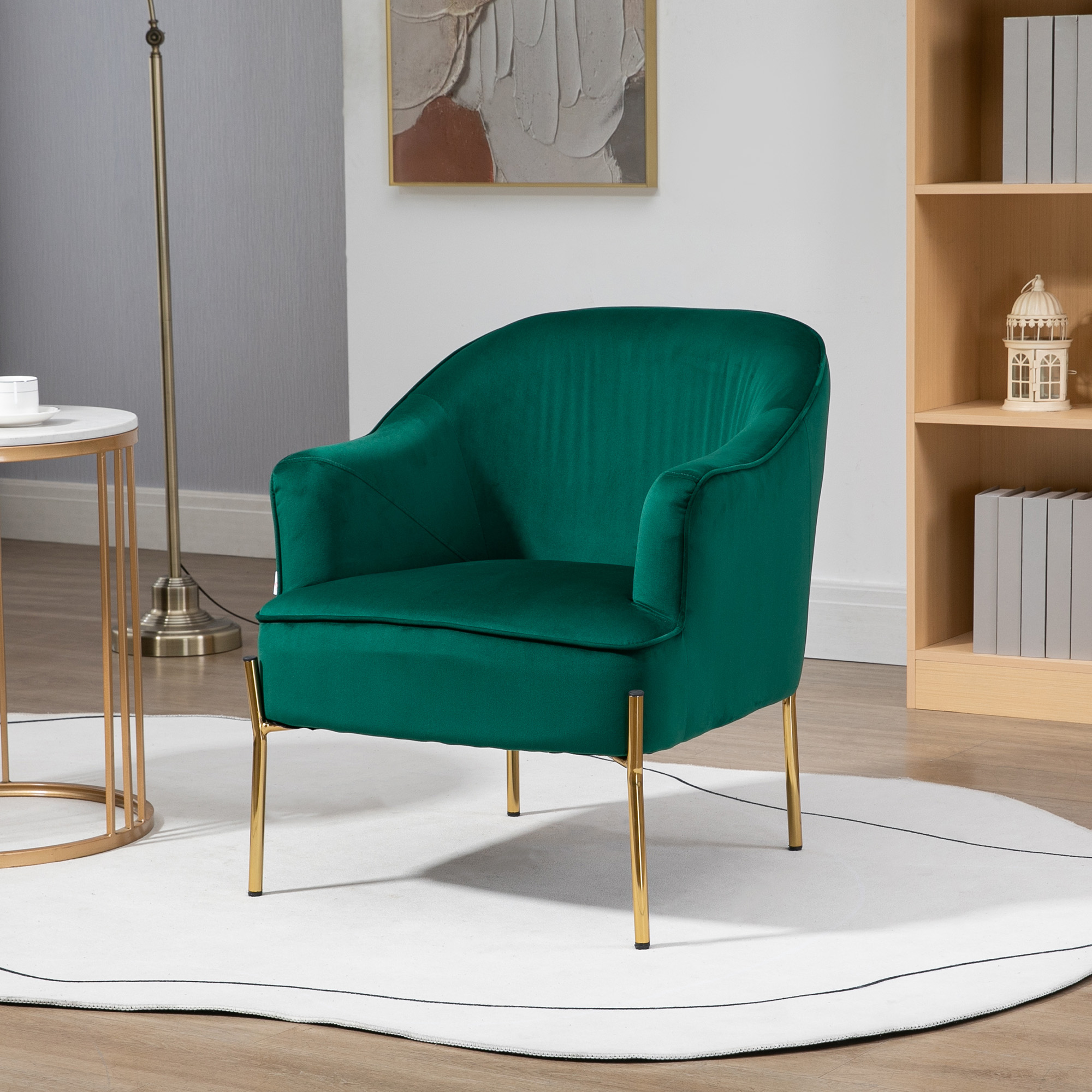 Poltrona in velluto verde con gambe dorate, in una stanza con tappeto bianco e arte.