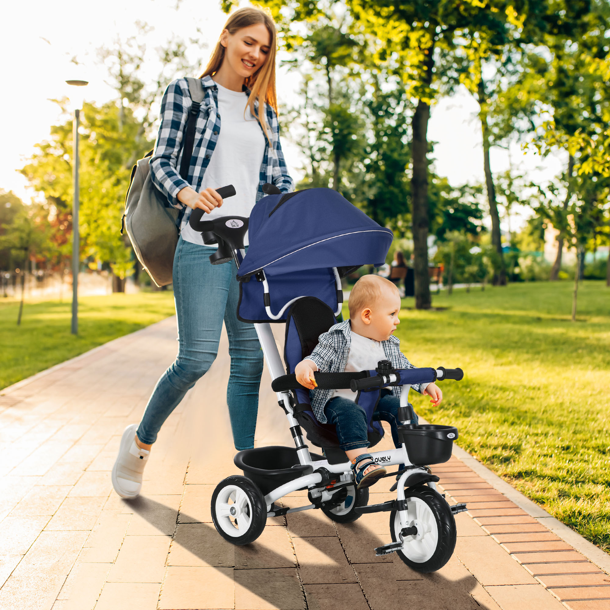 Una donna che spinge un triciclo con un bambino, su un sentiero pavimentato, con vegetazione.