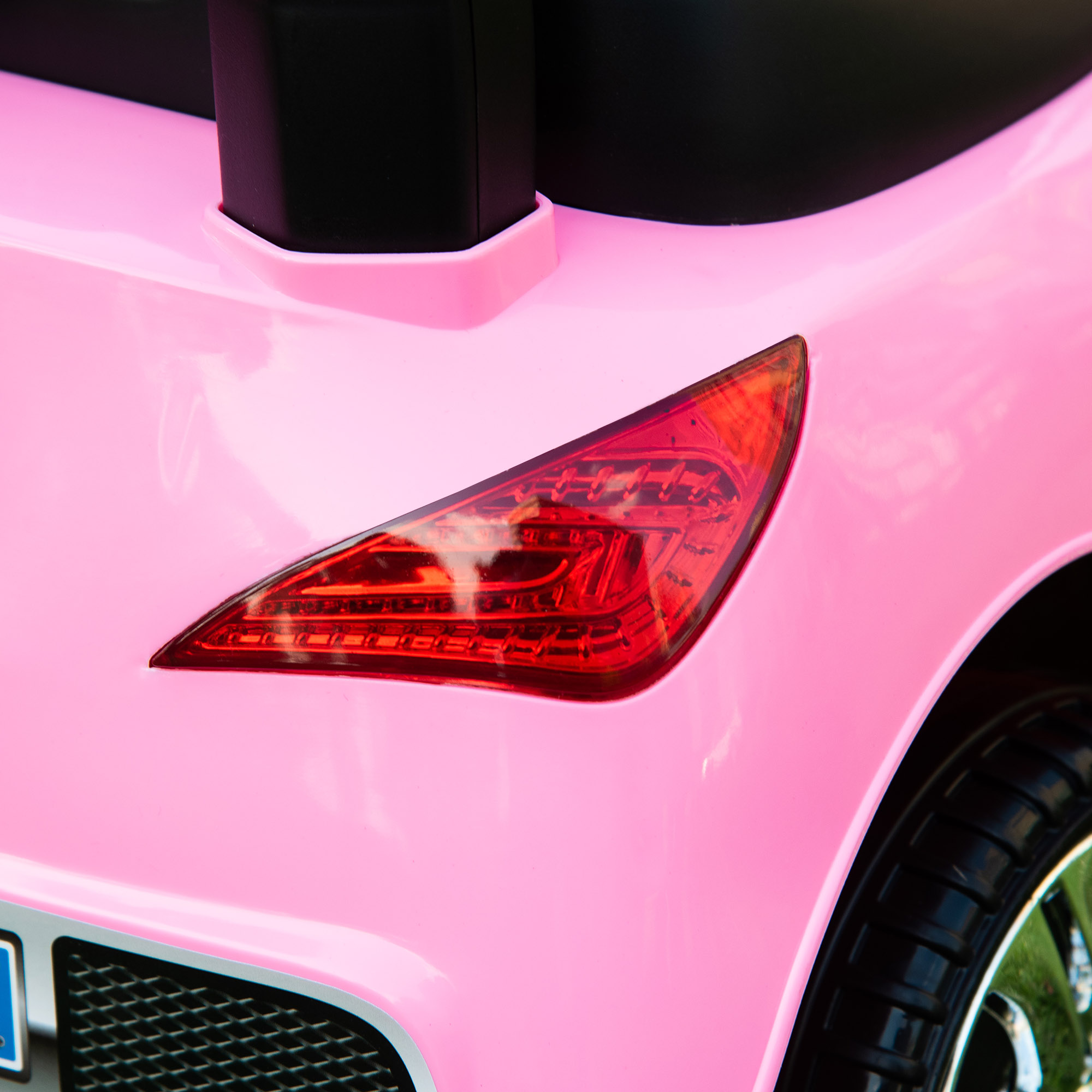Un primo piano del fanale posteriore rosso su un'auto giocattolo rosa.
