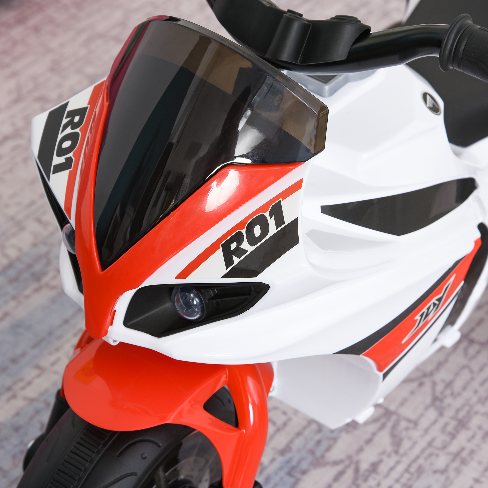 Una moto giocattolo bianca con dettagli rossi e neri e la parola 'R01'.