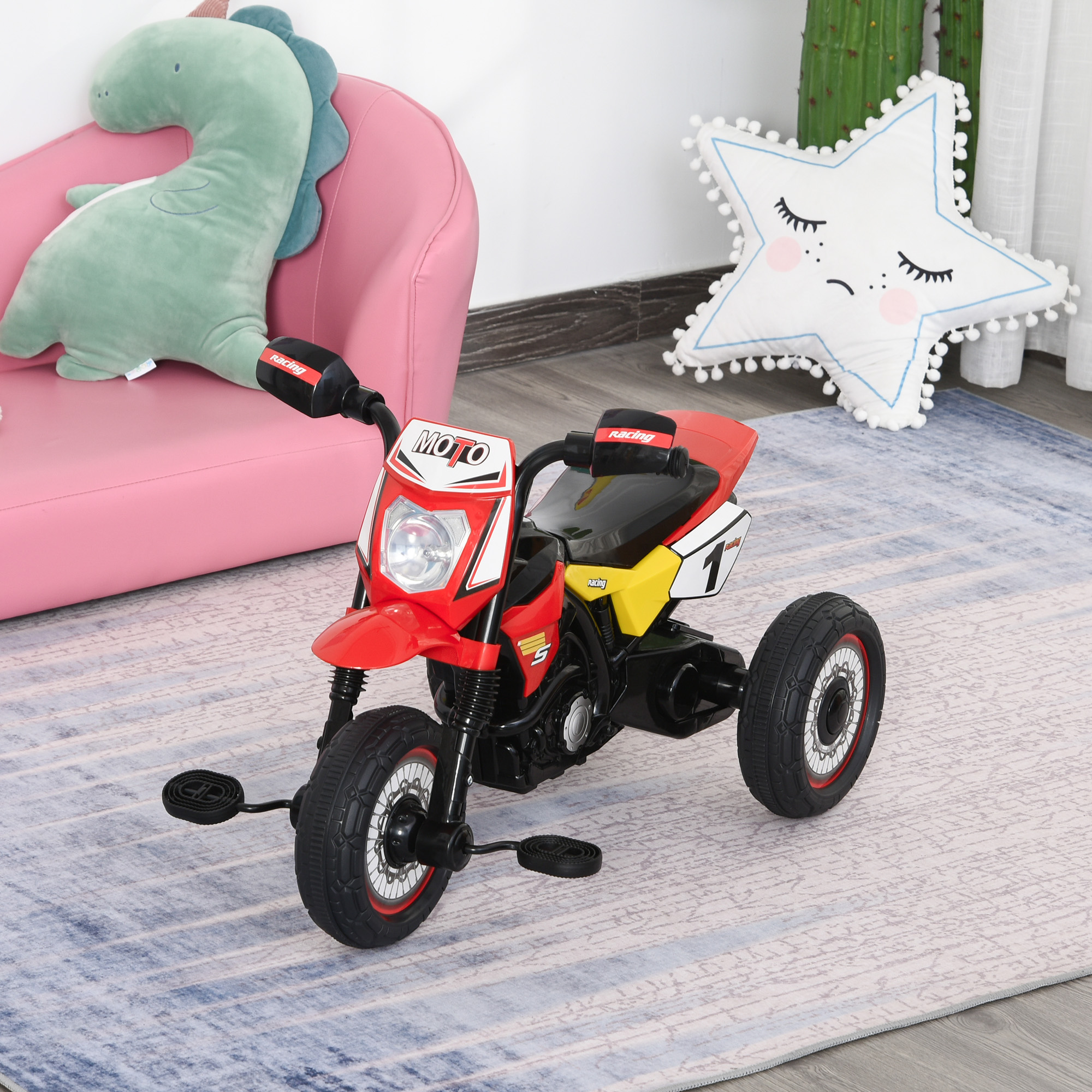 Moto giocattolo rossa, nera e gialla con tre ruote, in una stanza con una sedia rosa e un cuscino a stella.