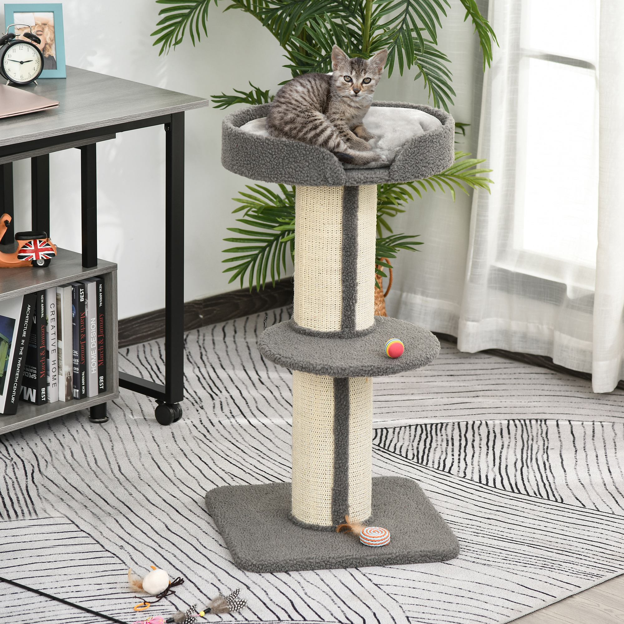 Albero per gatti con un gatto grigio sopra. L'albero ha un letto, piattaforme e tiragraffi.