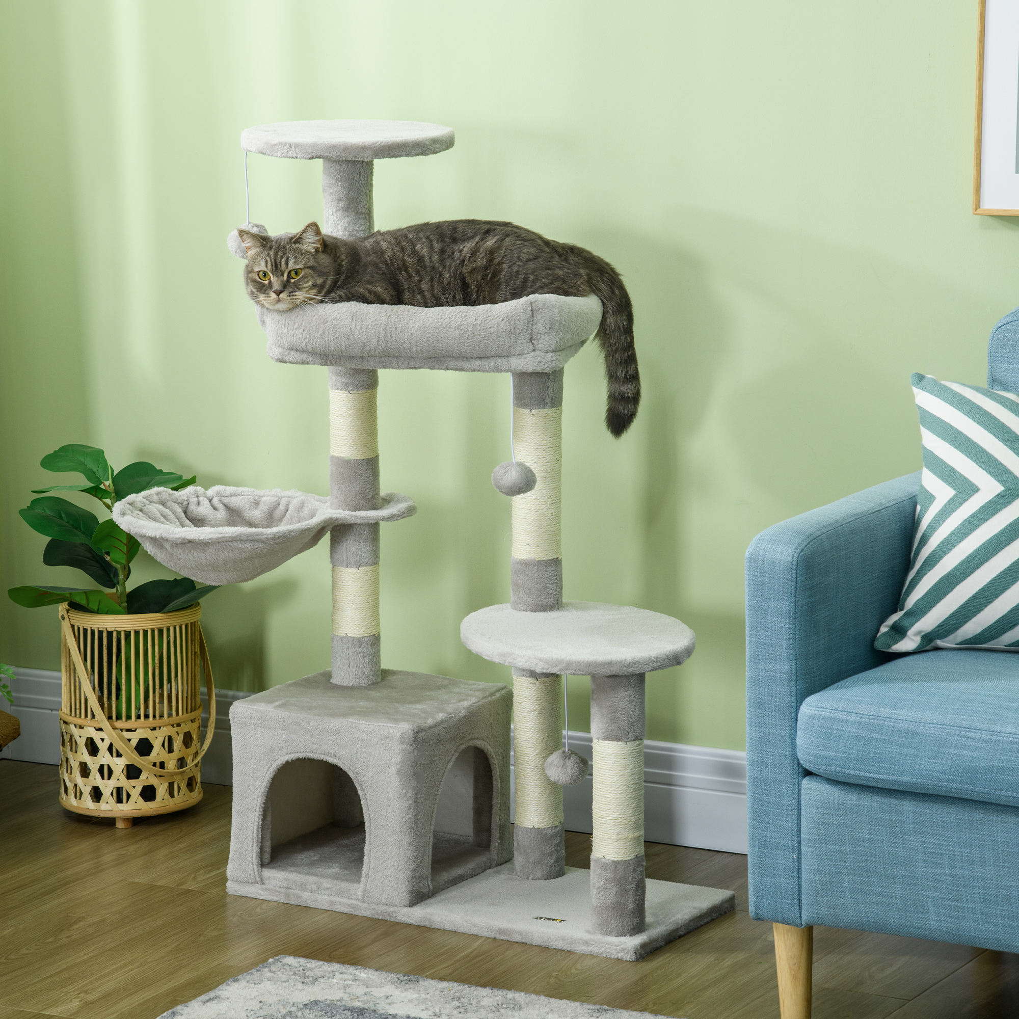 Gato en un árbol para gatos gris, con múltiples niveles y un rascador.