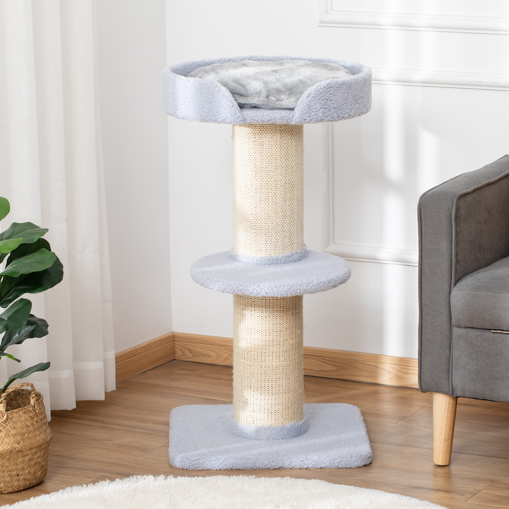 Albero per gatti grigio con tiragraffi, letto e base su pavimento in legno.
