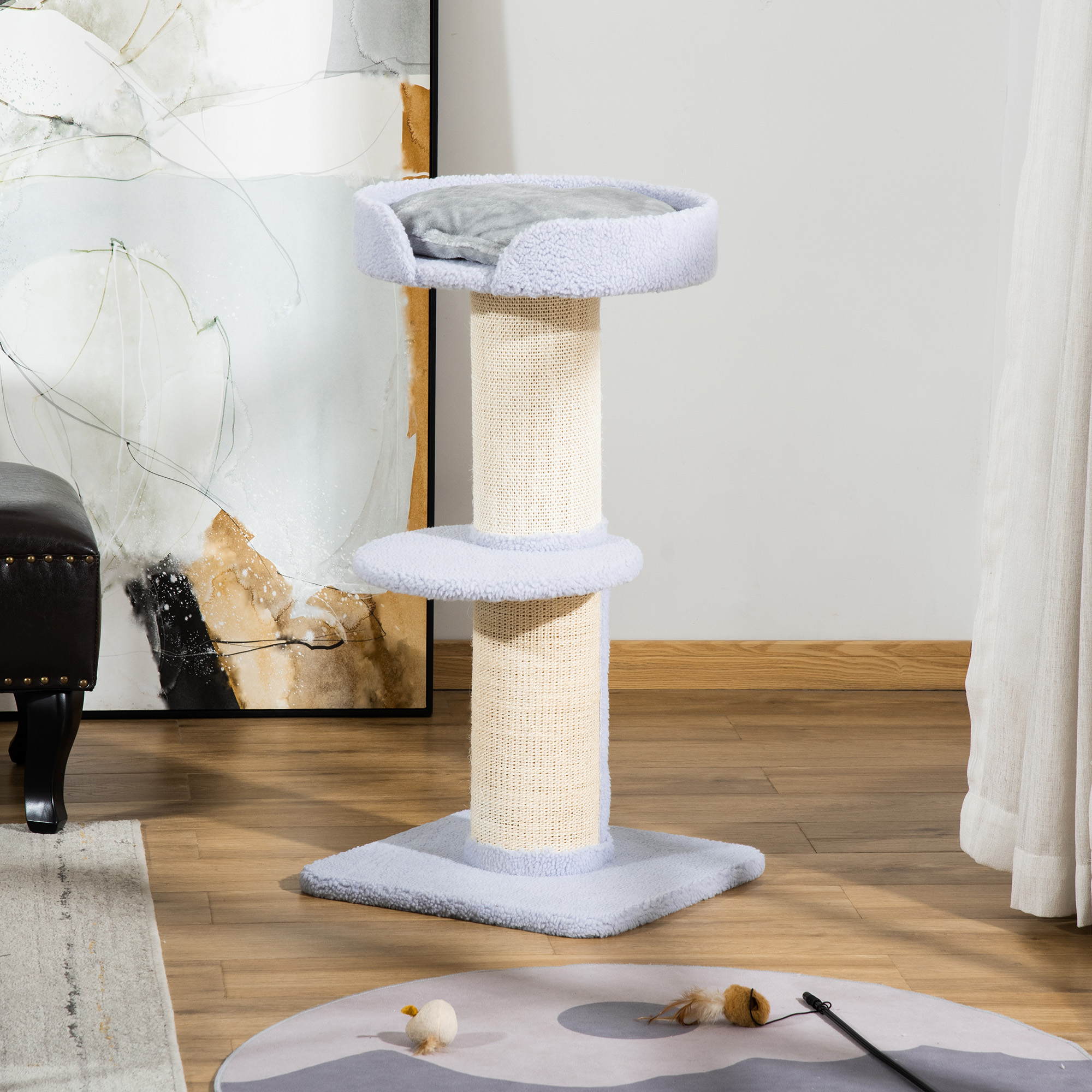 Un albero per gatti azzurro con piattaforma superiore circolare, piattaforma centrale e base in moquette. Parete bianca.