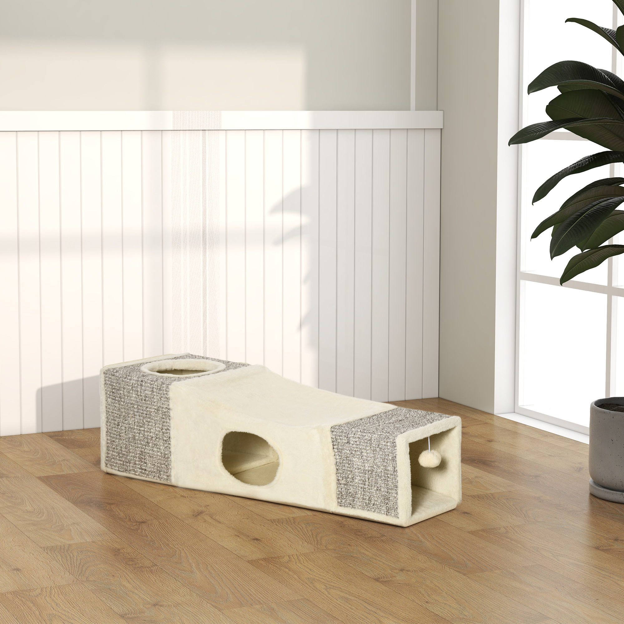 Un tunnel per gatti con un buco. È su un pavimento in legno vicino a una finestra.