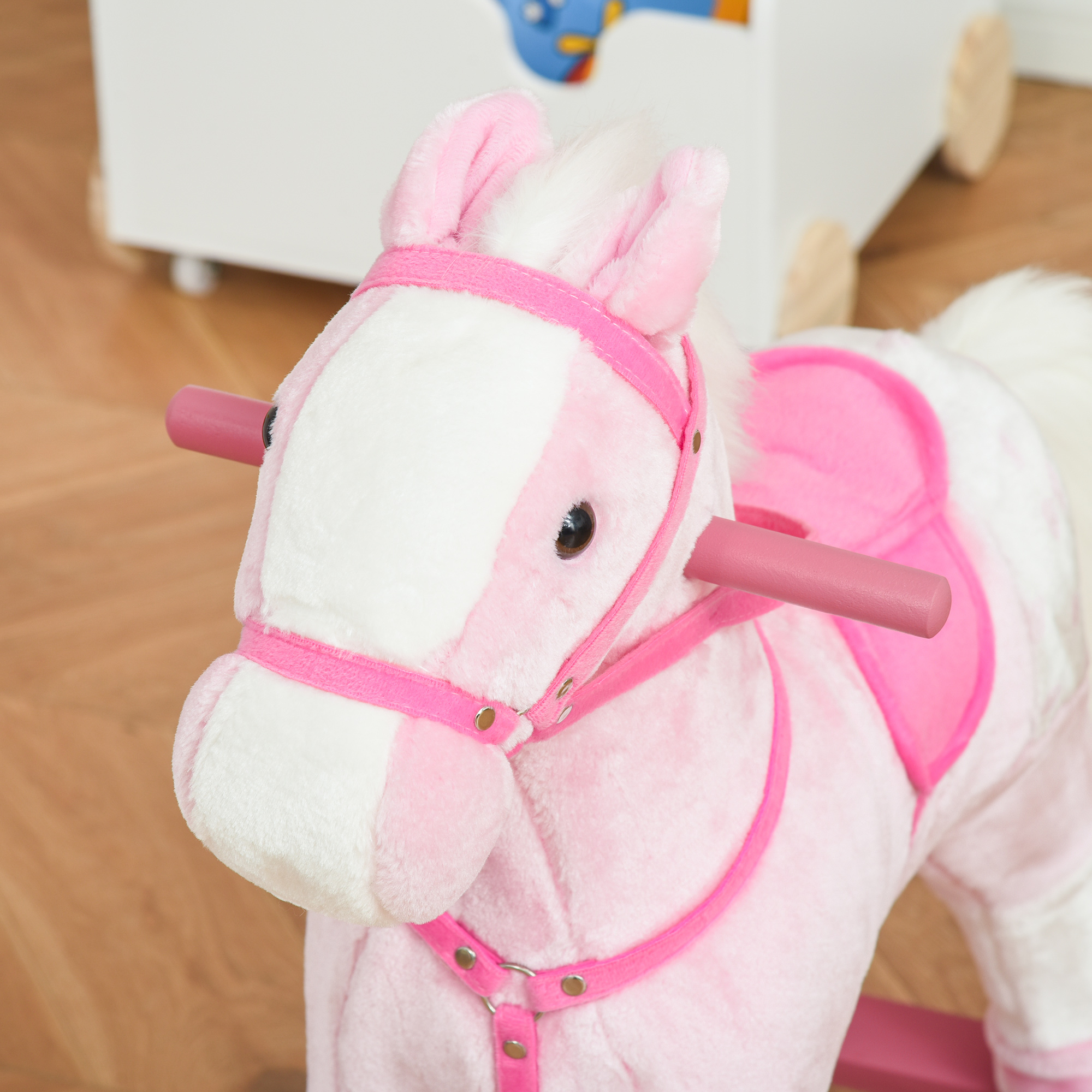 Un primo piano della testa di un cavallo a dondolo rosa con criniera rosa e bianca.