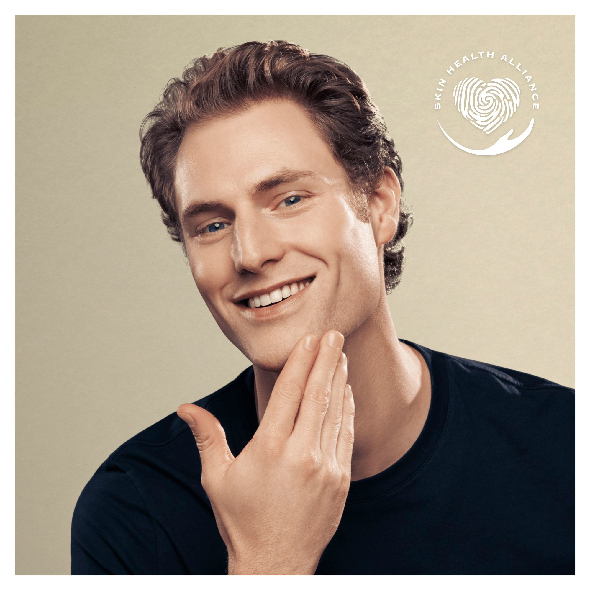 Hombre sonriendo, sosteniendo su rostro con las manos. Logotipo de Skin Health Alliance en la esquina.