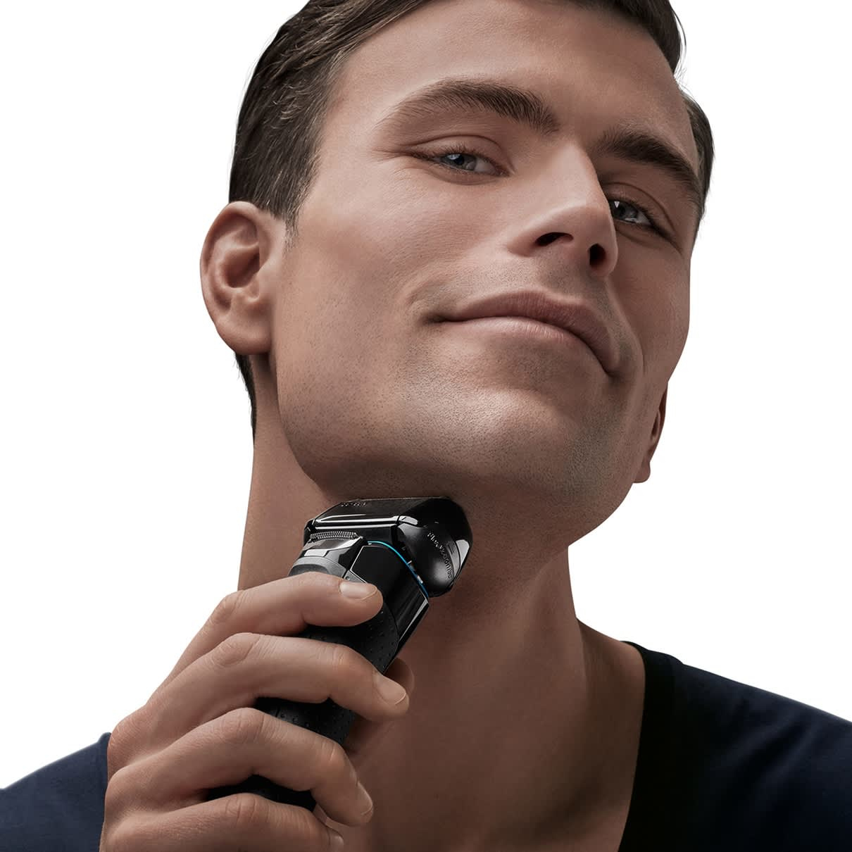 Mężczyzna goli szyję czarną golarką Braun; gładko ogolona twarz.