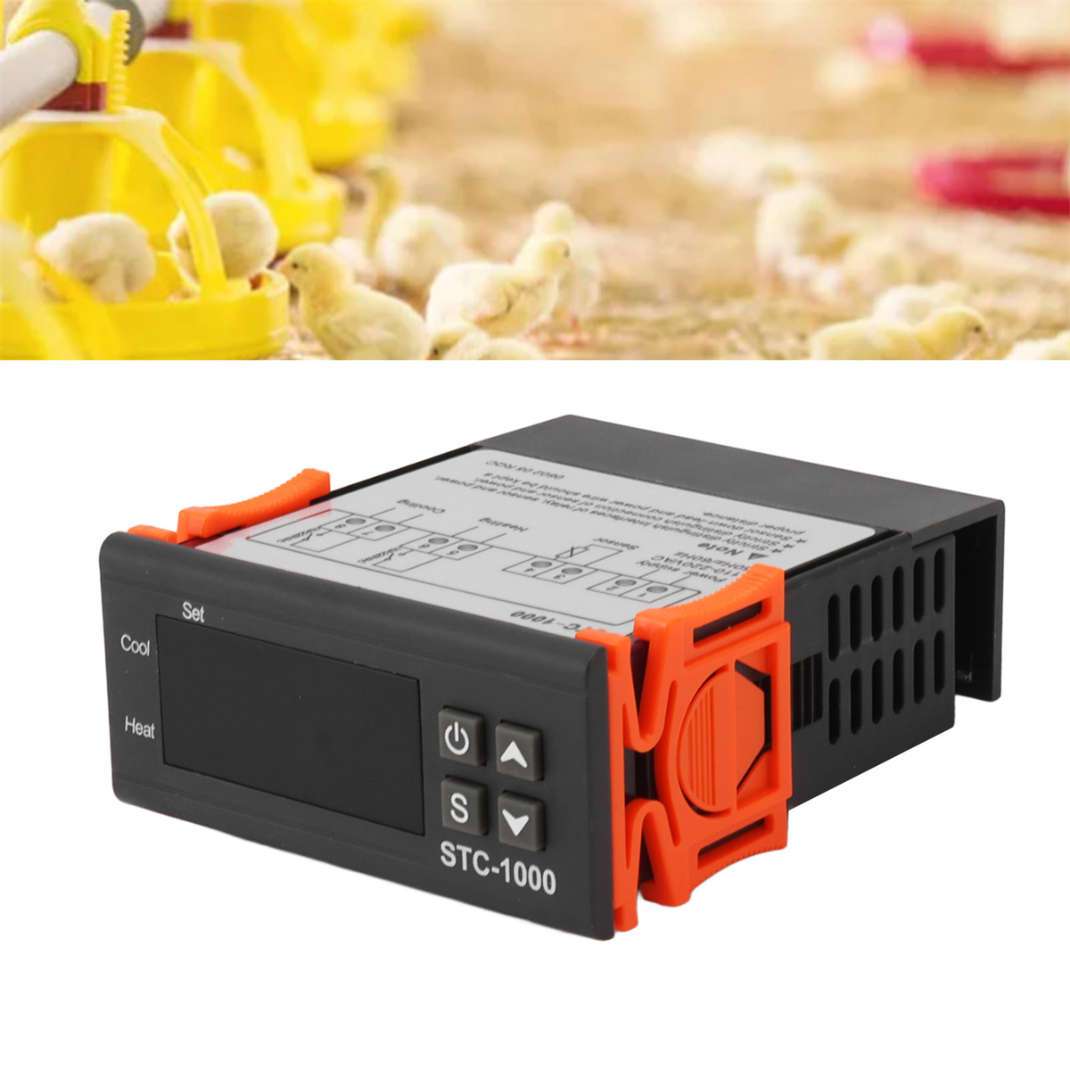 Ein schwarz-oranger digitaler Temperaturregler mit Knöpfen und Display. Küken sind im Hintergrund.