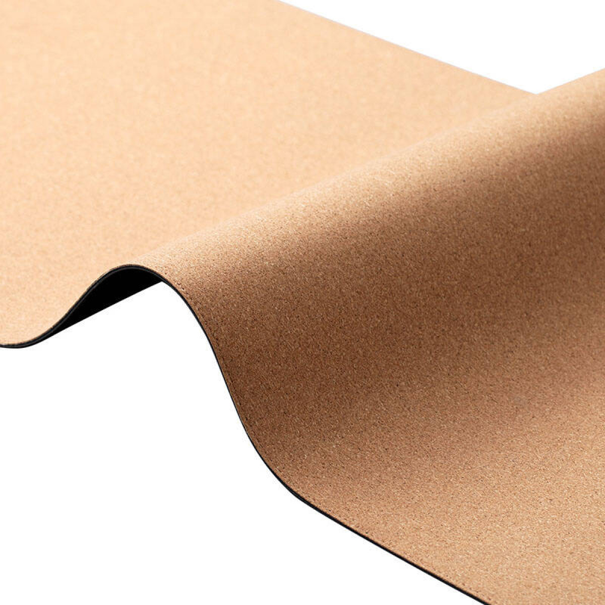 Zbliżenie brązowej maty do jogi, z czarnym spodem, lekko zwiniętej.