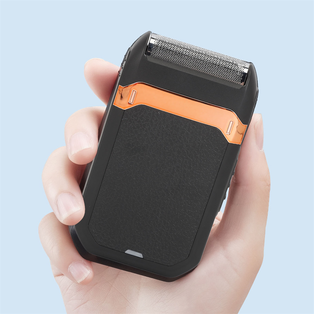 Schwarz-oranger Elektrorasierer in einer Hand, hellblauer Hintergrund.