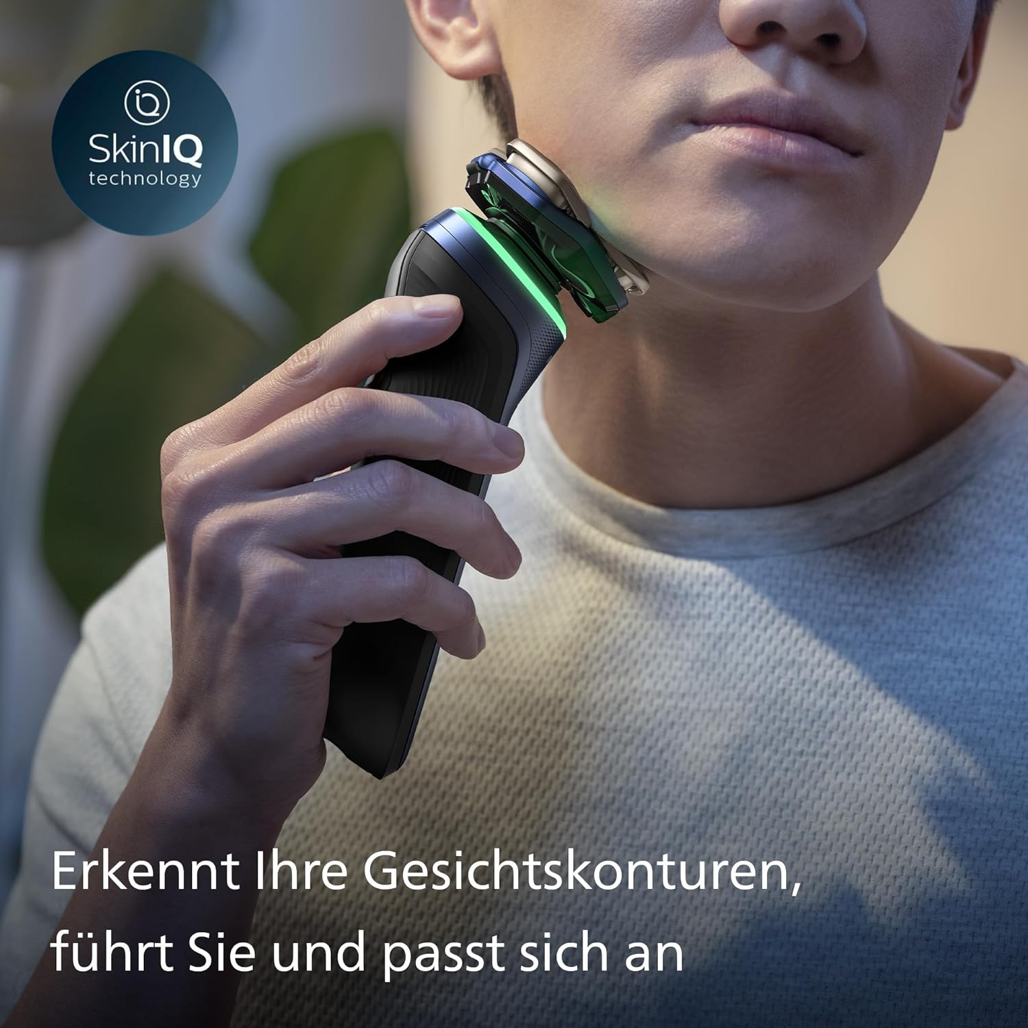 Uomo che si rade la faccia con un rasoio elettrico Philips.