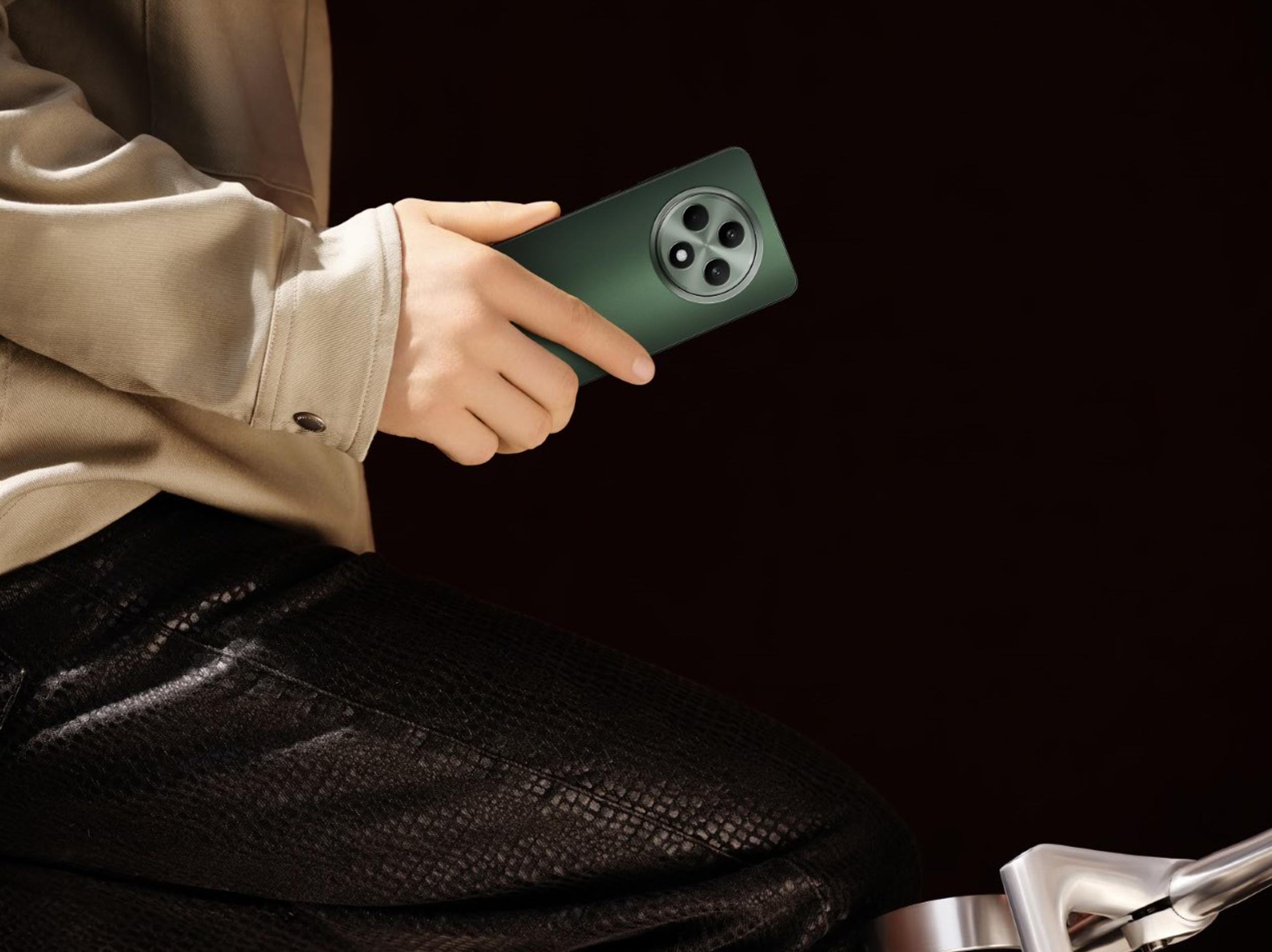 Osoba trzyma zielony smartfon z potrójnym aparatem na ciemnym tle.