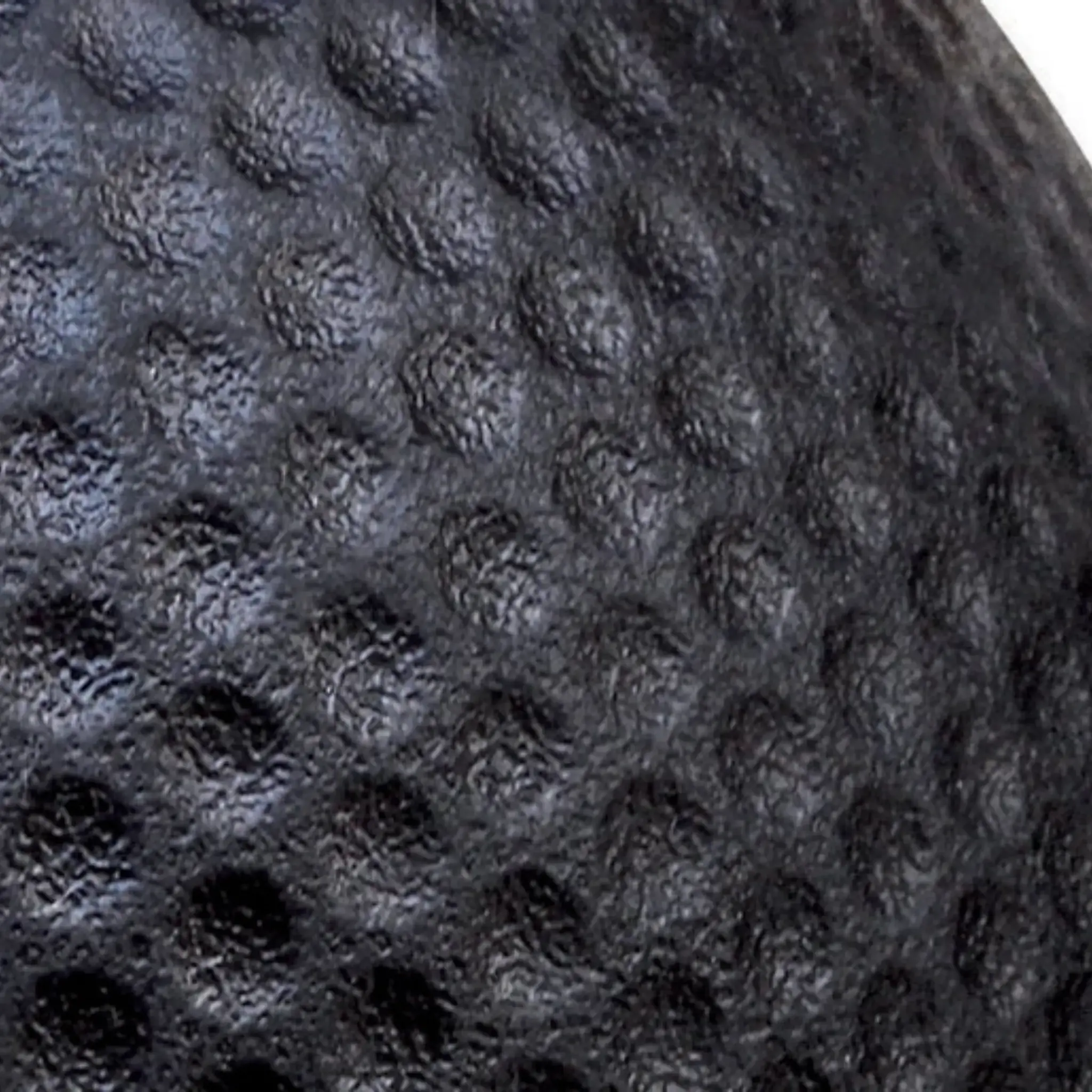 Gros plan d'une surface noire texturée avec de petites bosses.