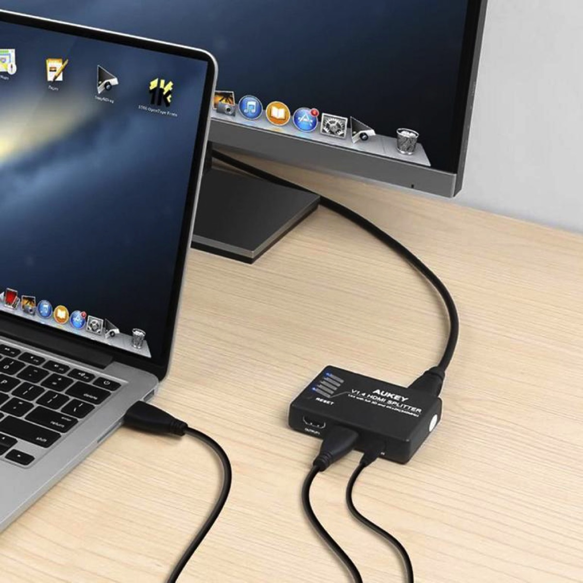Ein Laptop, der über einen schwarzen HDMI-Splitter mit einem Monitor verbunden ist.
