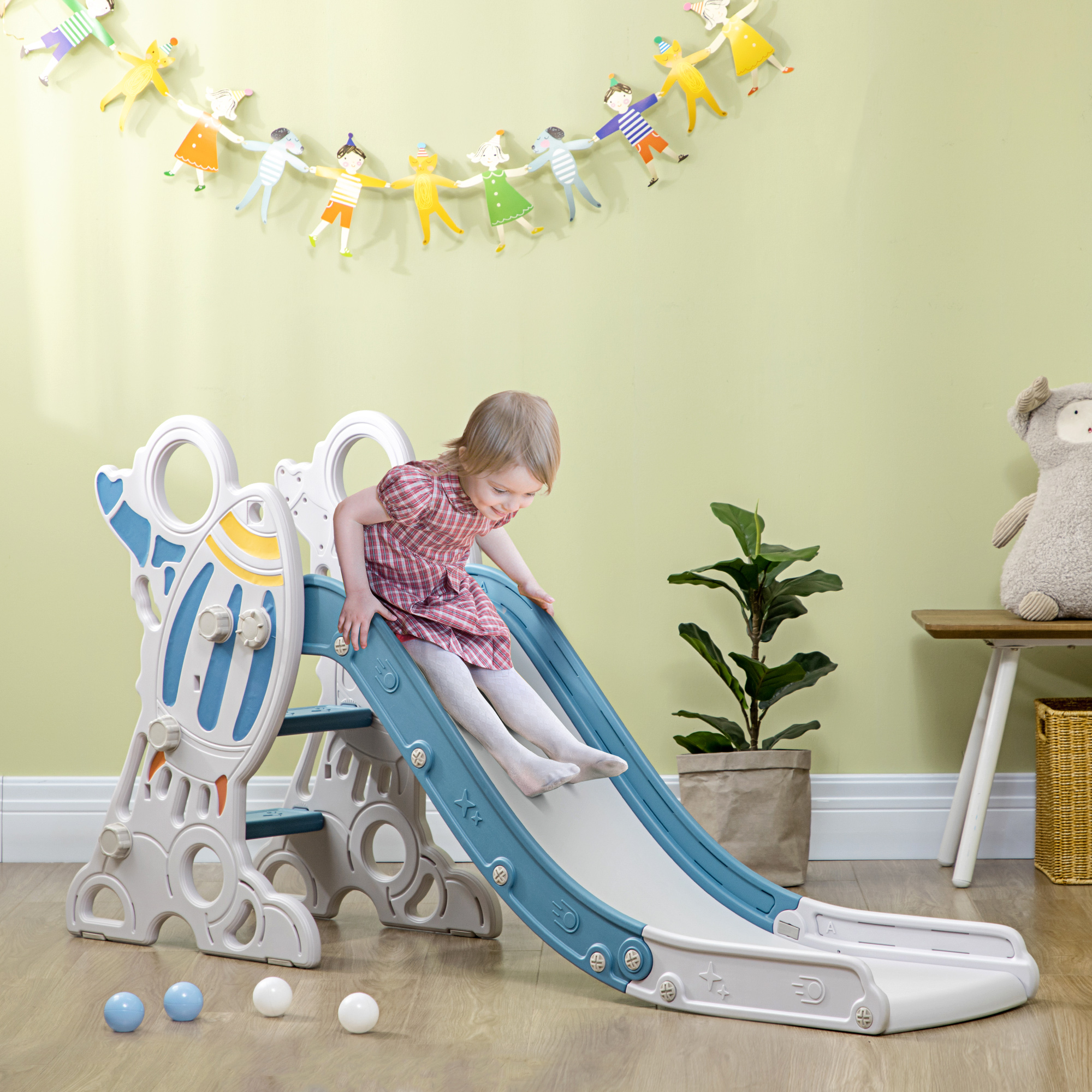 Un bambino scivola giù da uno scivolo blu e bianco. L'arredamento è sullo sfondo.