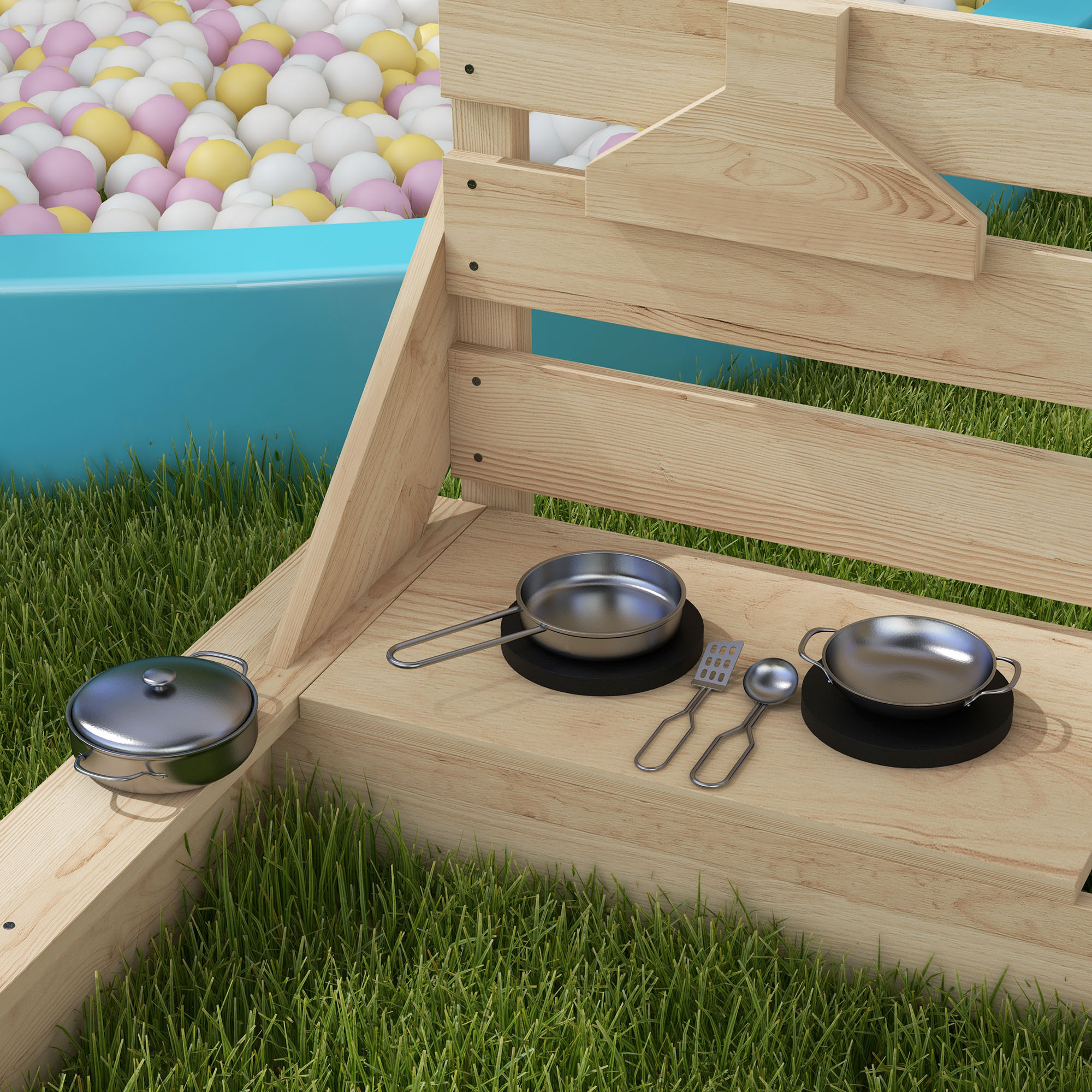 Cucina giocattolo in legno con utensili da cucina e una piscina di palline sullo sfondo.