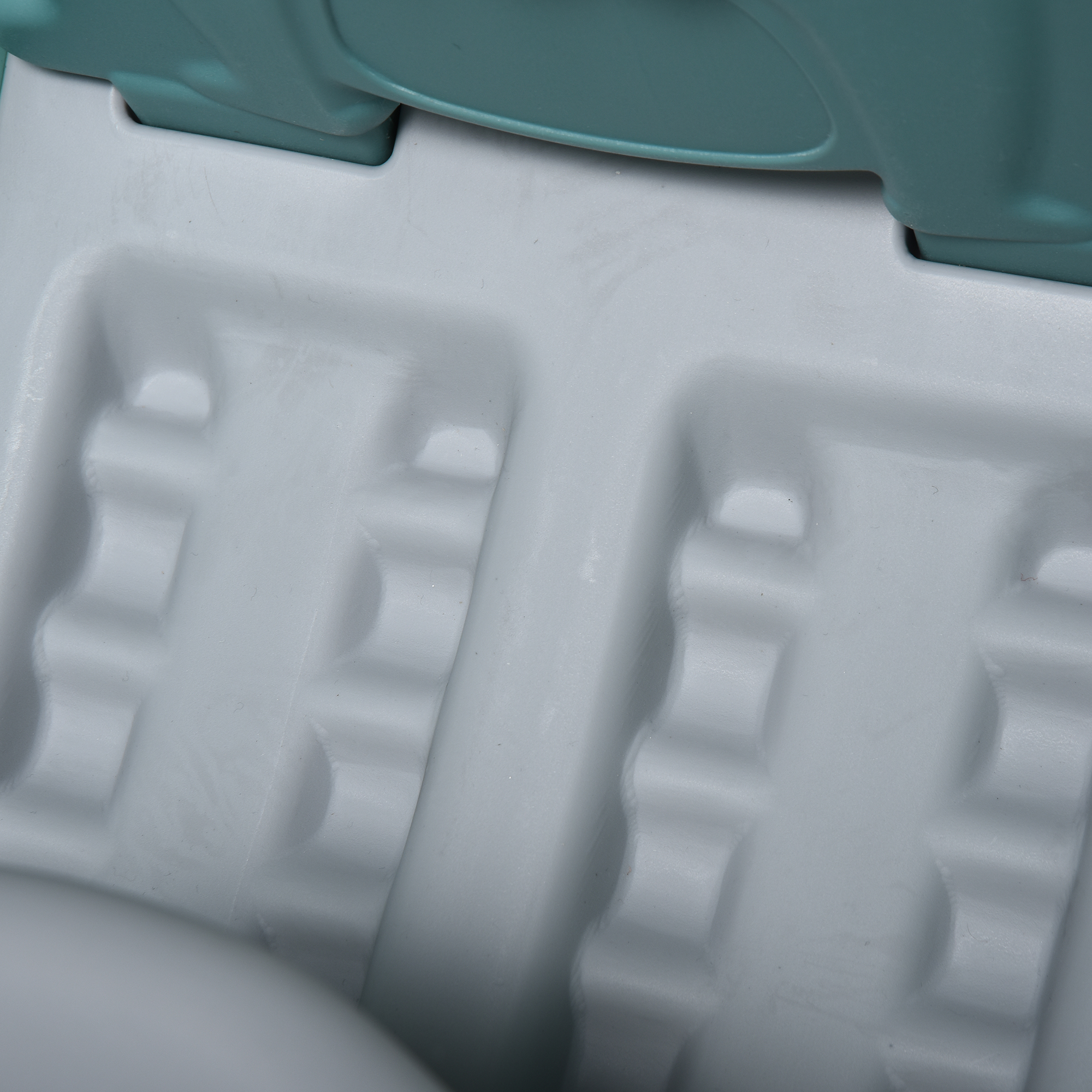 Primo piano dell'interno di uno scivolo. Plastica grigia con rientranze per i piedi.