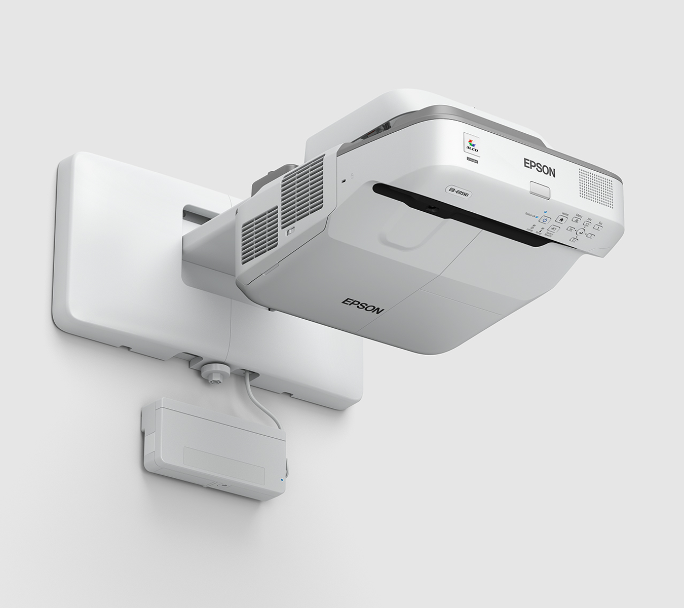 Proyector Epson blanco montado en una pared, con cable de alimentación y caja de control.