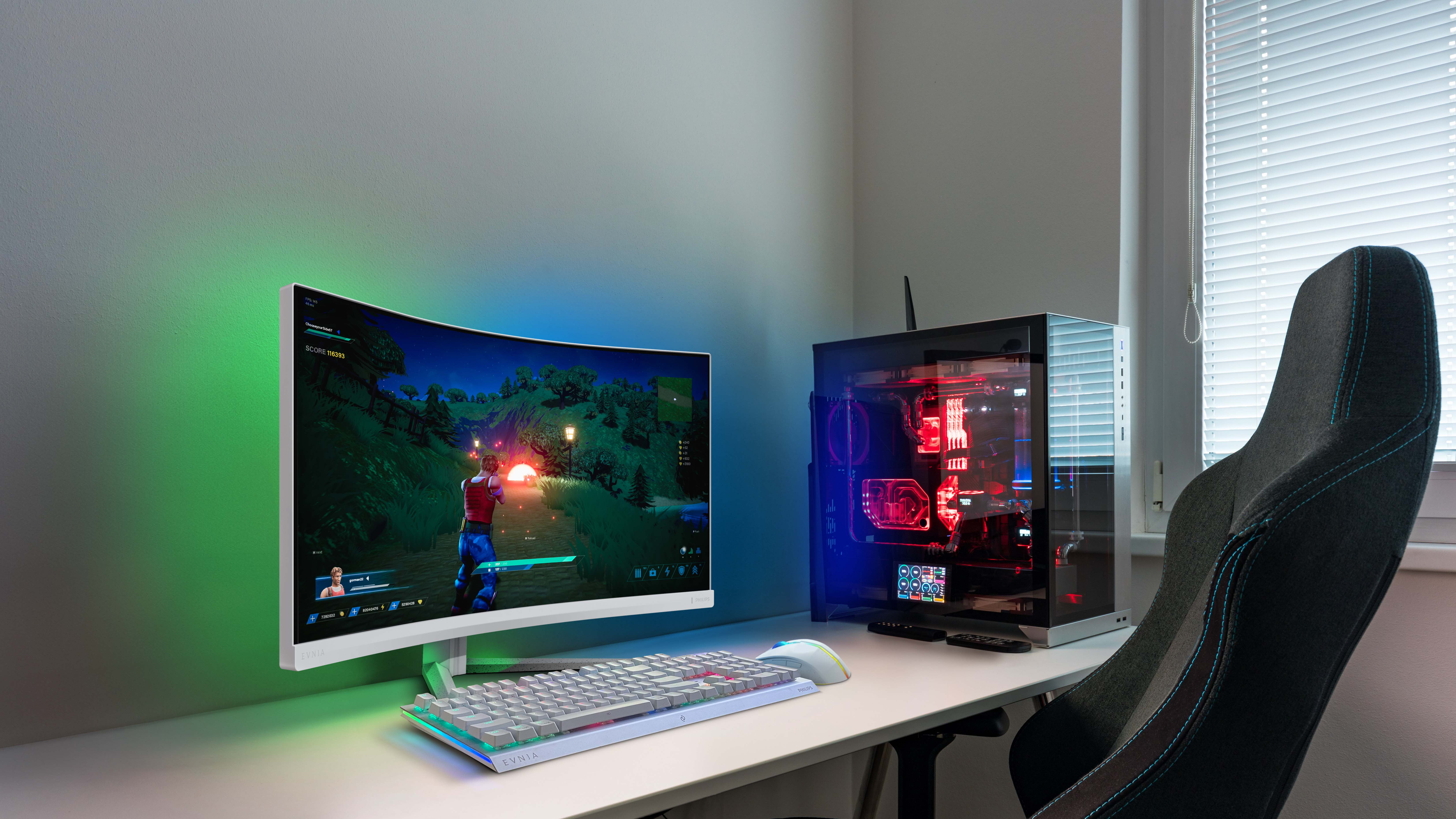 Konfiguracja do gier: zakrzywiony monitor, klawiatura, mysz, PC i krzesło.