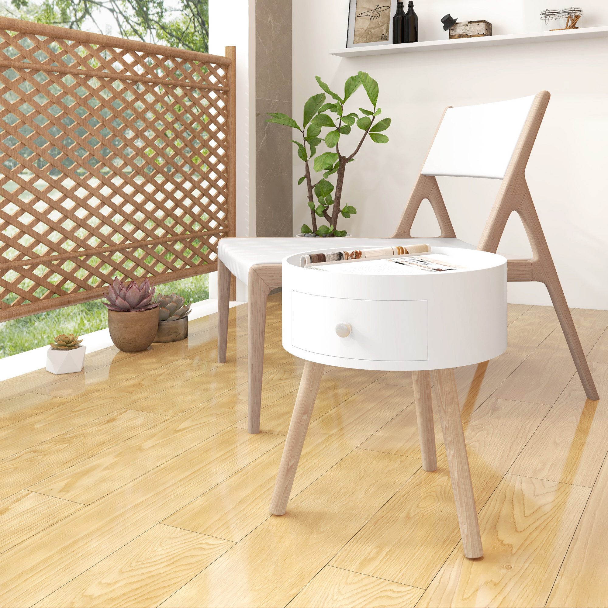 Un tavolino bianco con cassetto e gambe in legno, accanto a una sedia e una pianta.
