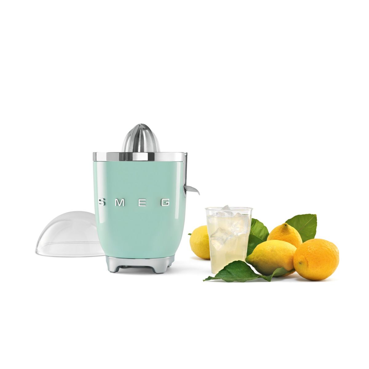 Miętowa wyciskarka Smeg z cytrynami, szklanką soku i pokrywką.