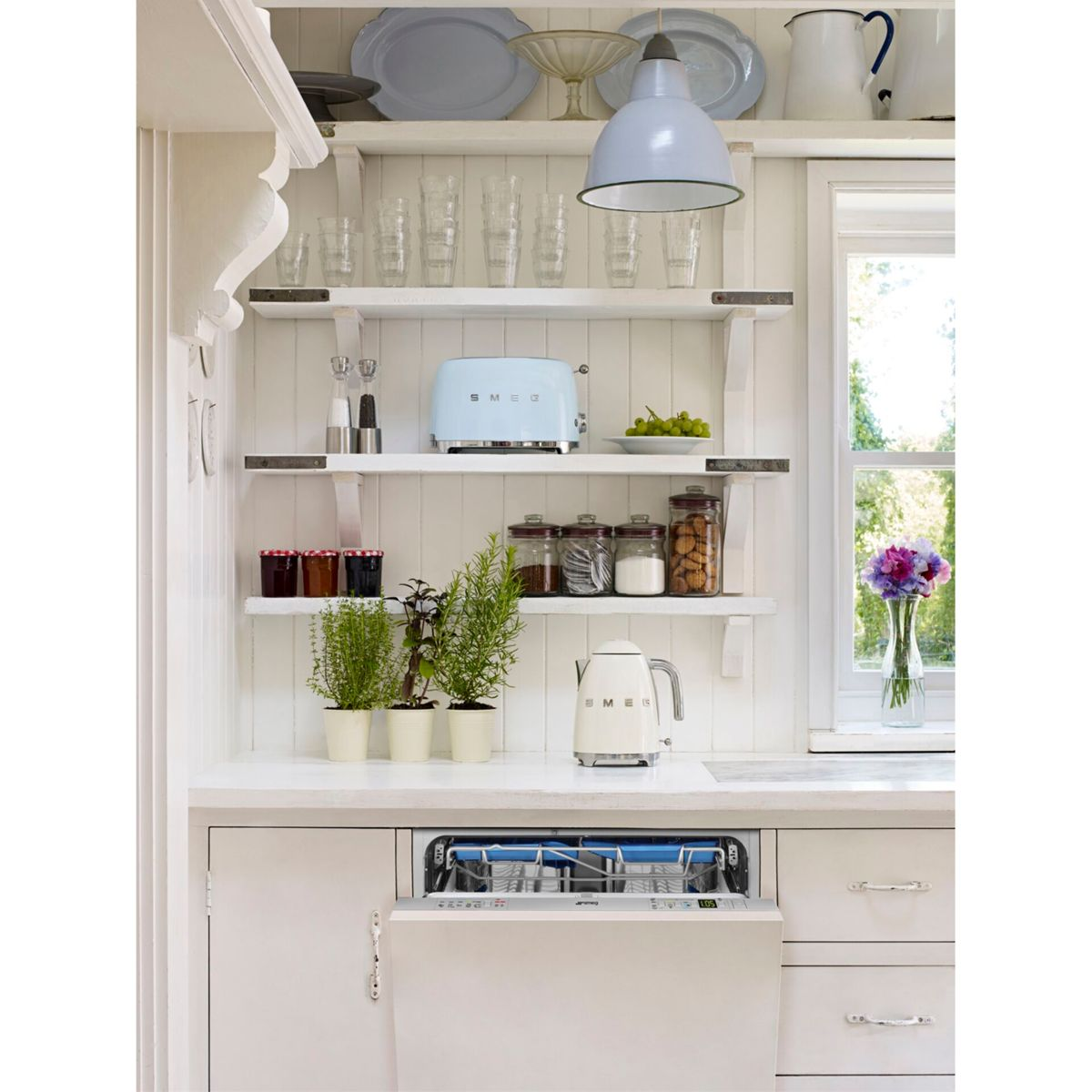 Kuchnia z półkami, tosterem, czajnikiem i zmywarką. Biały i błękitny.