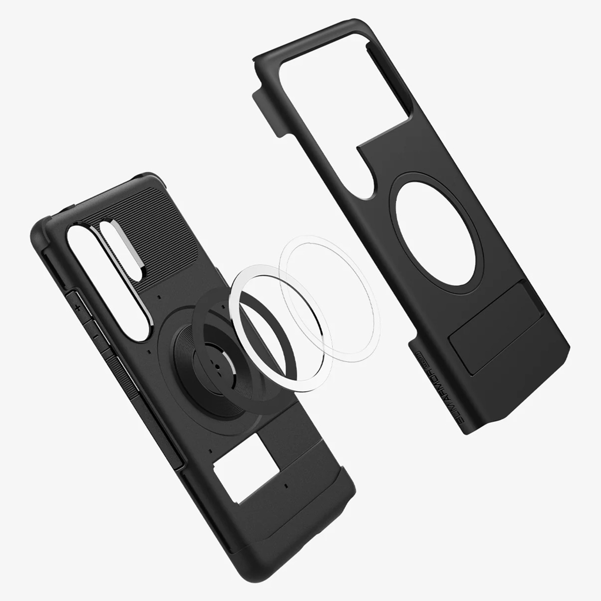 Zwarte telefoonhoes onderdelen. Toont ring en standaard apart. Spigen-logo zichtbaar.