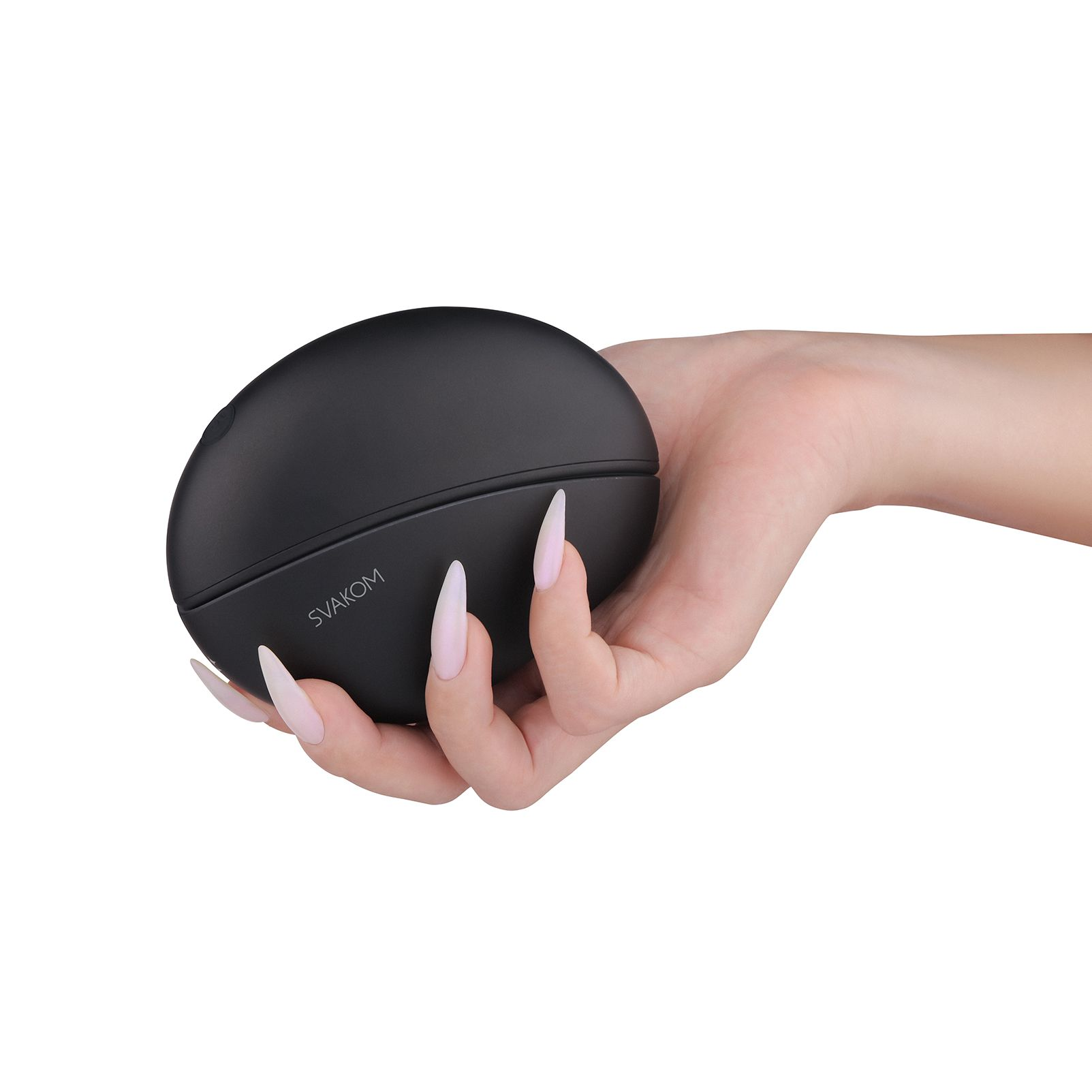 Czarne, owalne urządzenie trzymane w dłoni z długimi, zadbanymi paznokciami.