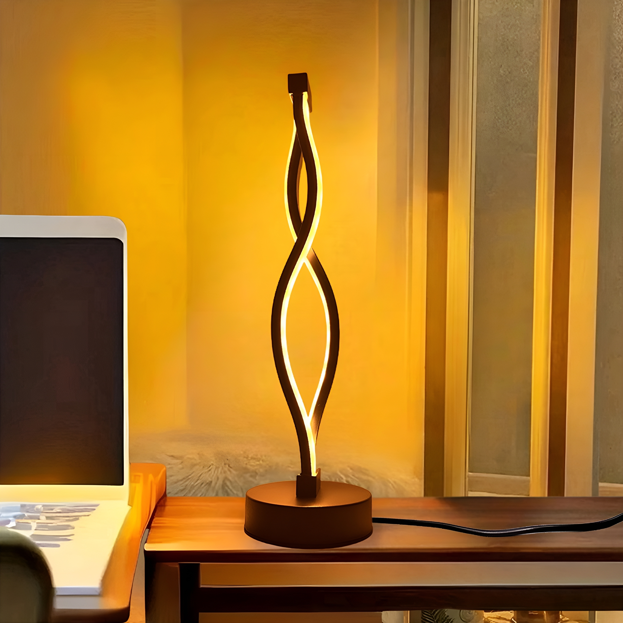 Moderne schwarz-goldene Schreibtischlampe mit Spiraldesign, isoliert auf weißem Grund.