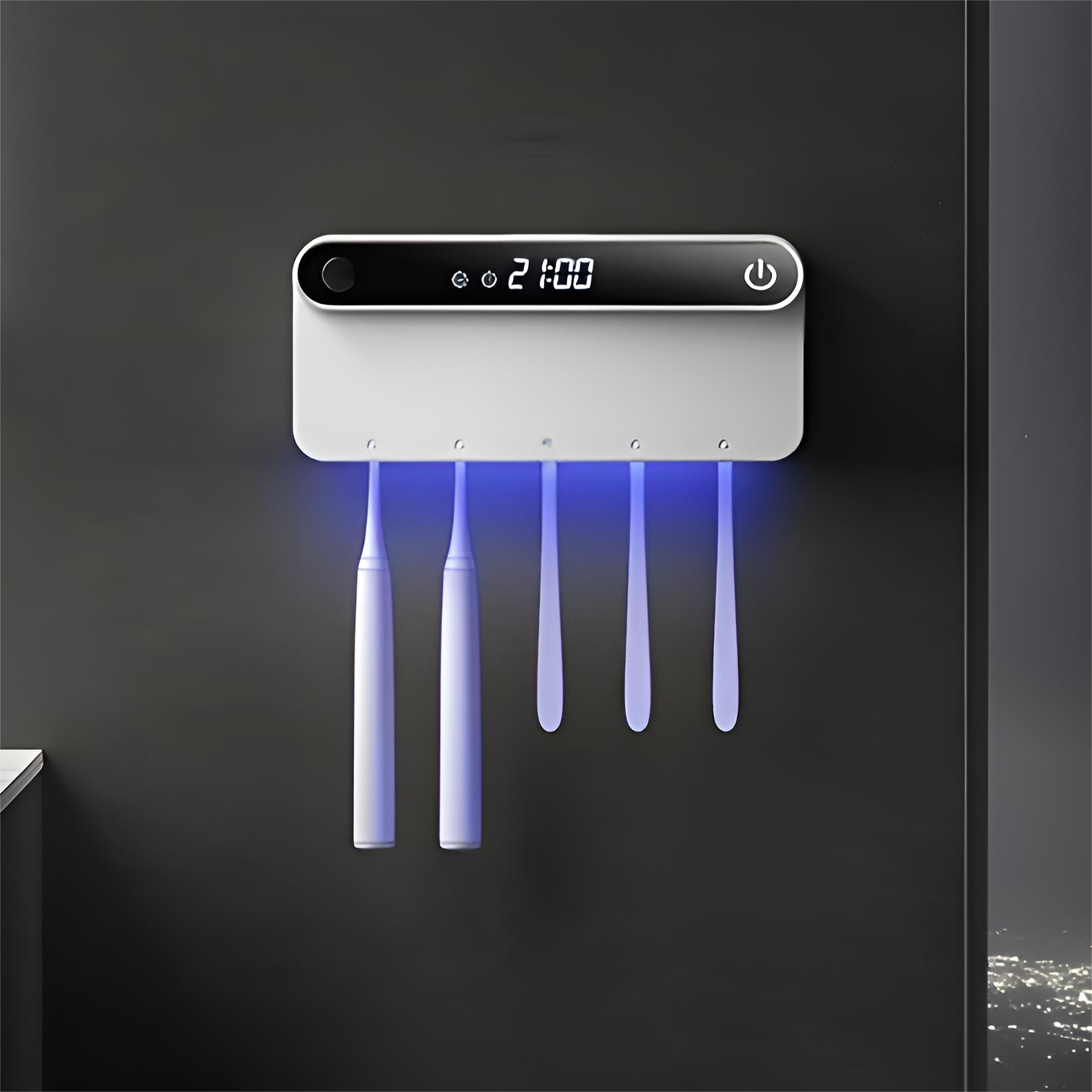 Ein wandmontierter Zahnbürstensterilisator mit Digitaluhr und vier Zahnbürsten, an einer dunklen Wand.