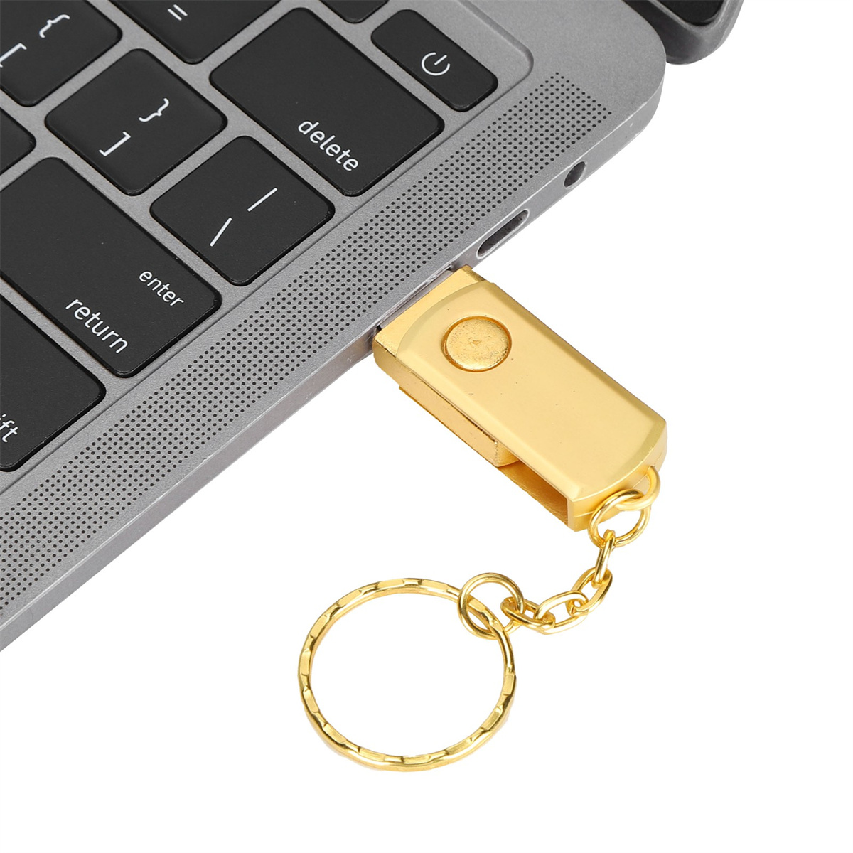 Goldener USB-Stick an einem Laptop angeschlossen. Ein goldener Schlüsselanhängerring befestigt.