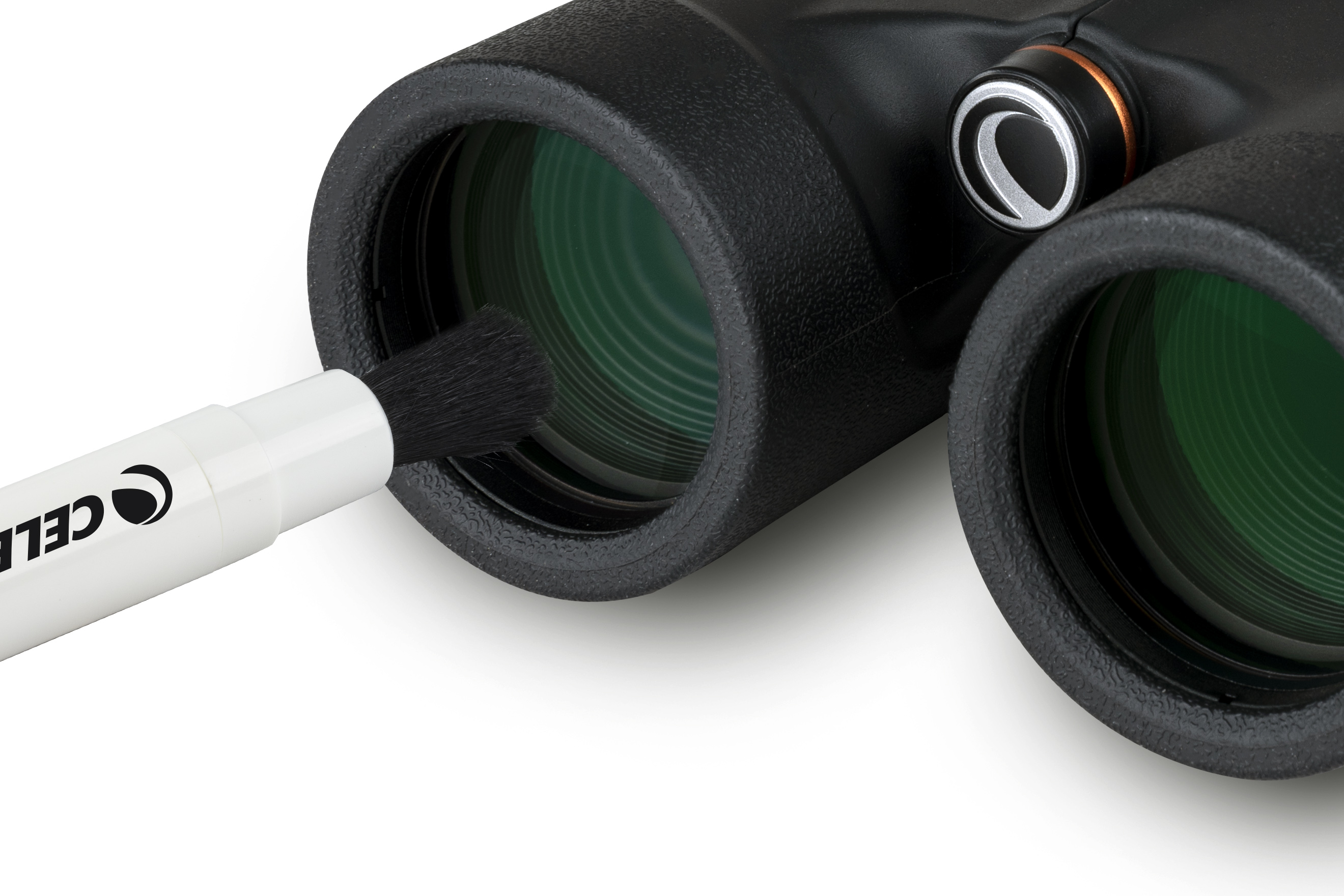 Fernglas mit grünen Linsen, das mit einer Bürste gereinigt wird. Schwarz und Weiß auf weißem Hintergrund.