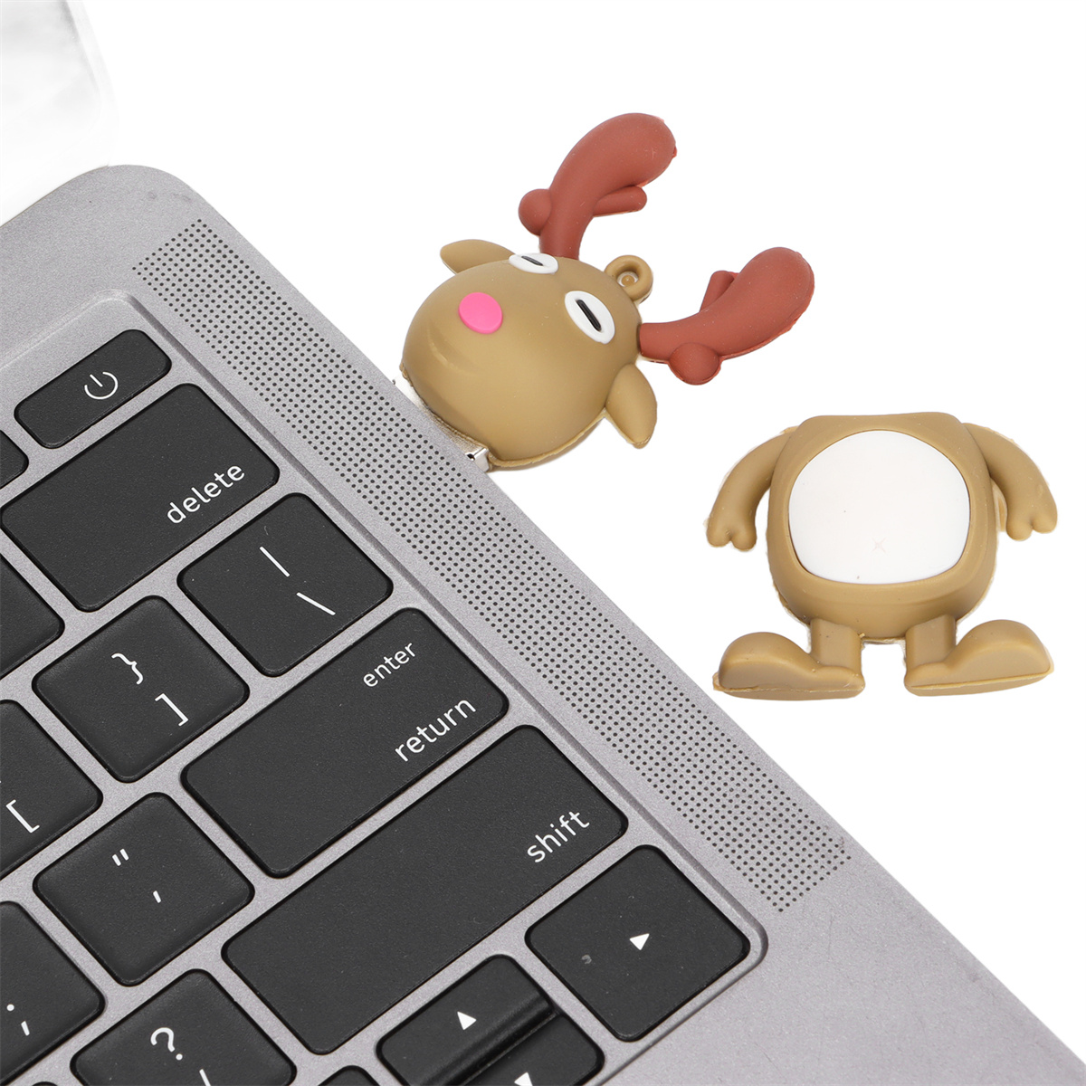 Eine Laptop-Tastatur mit zwei USB-Laufwerken in Form eines Rentiers und einem Körper daneben.