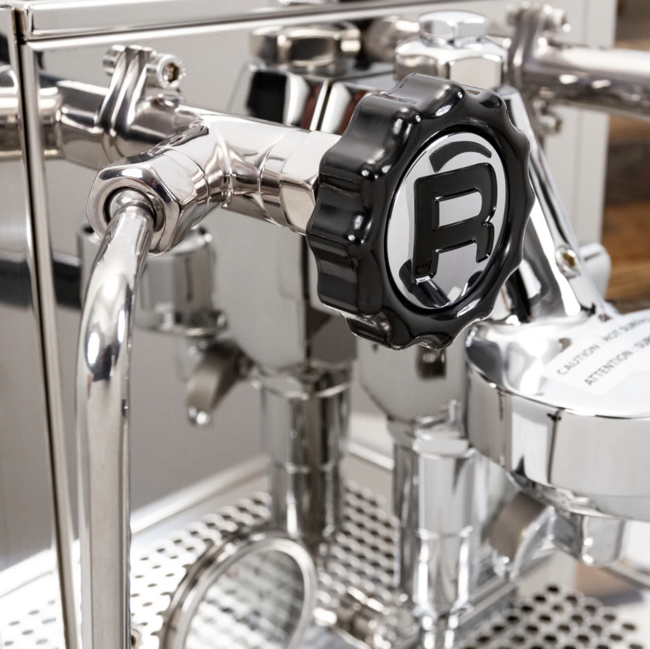 Primo piano della manopola cromata della macchina per espresso.