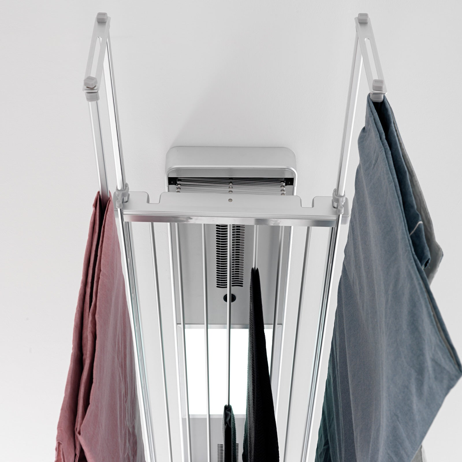 Uno stendibiancheria con vestiti appesi, montato su un soffitto bianco.